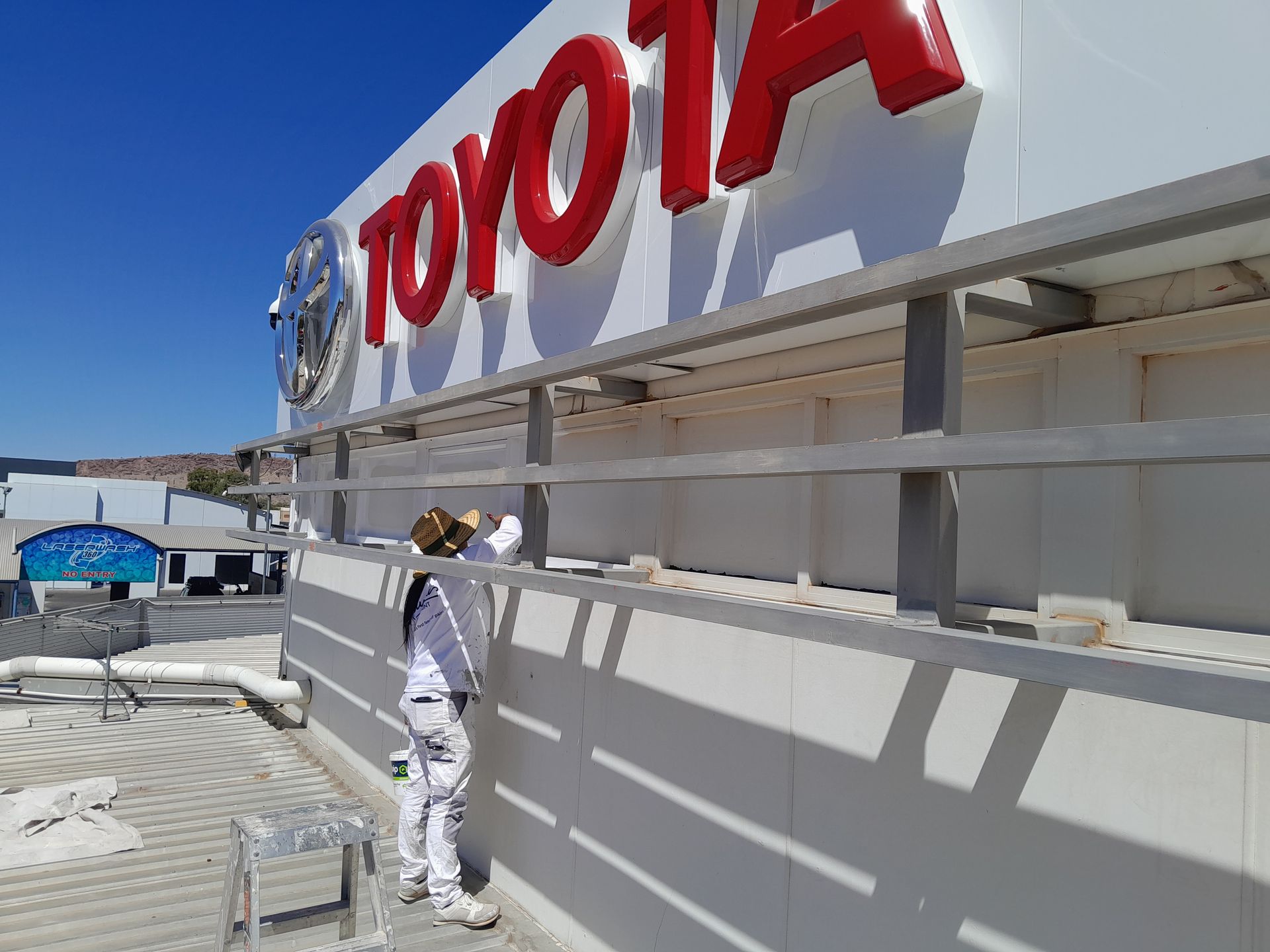 A Painter Painting A Toyota Building White — Ross Painting In Ciccone, NT