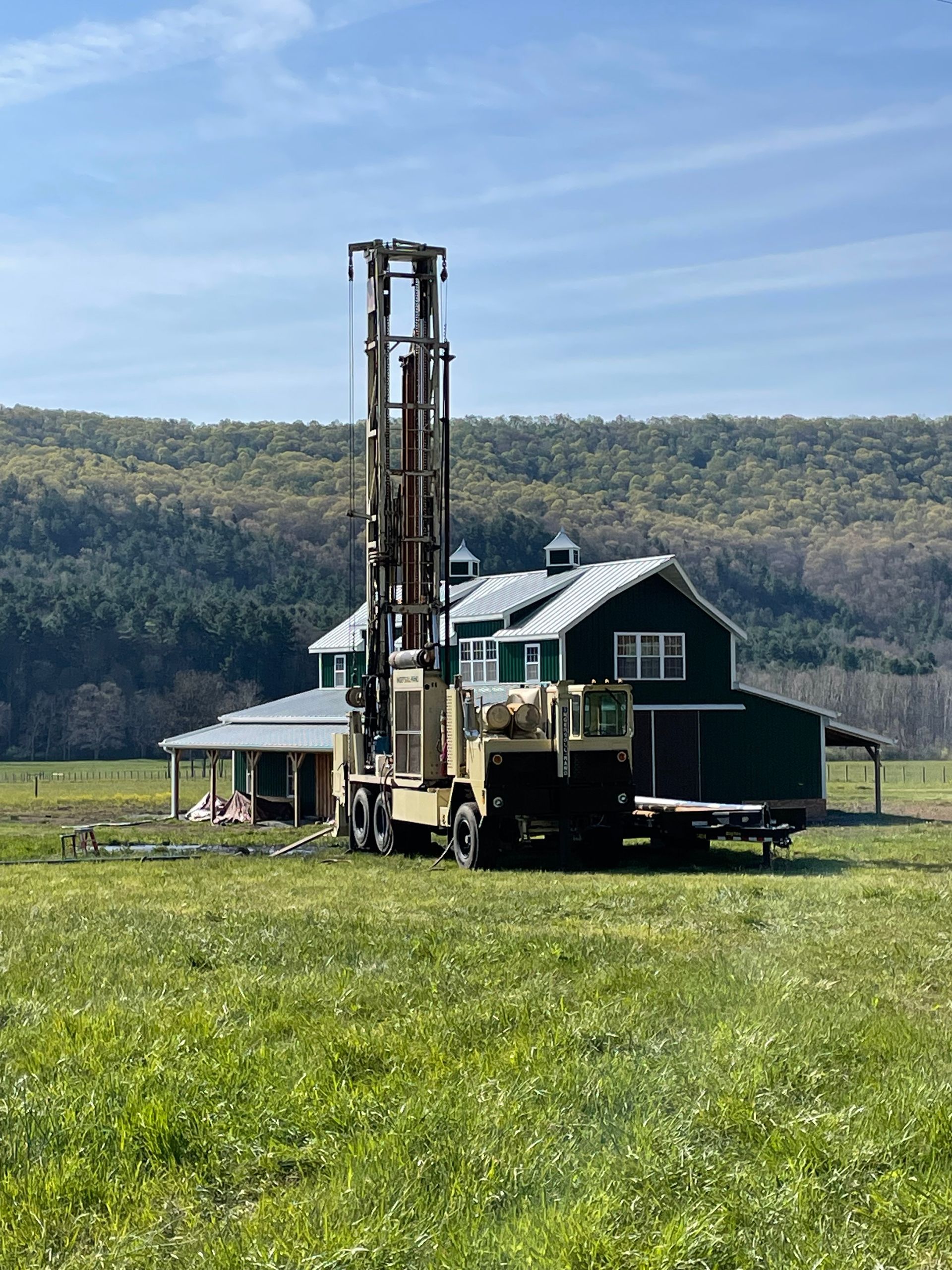 Large Truck Parked in a Grassy Field in Front of a Green Barn | Buchanan, VA | Lester Well Drilling Inc