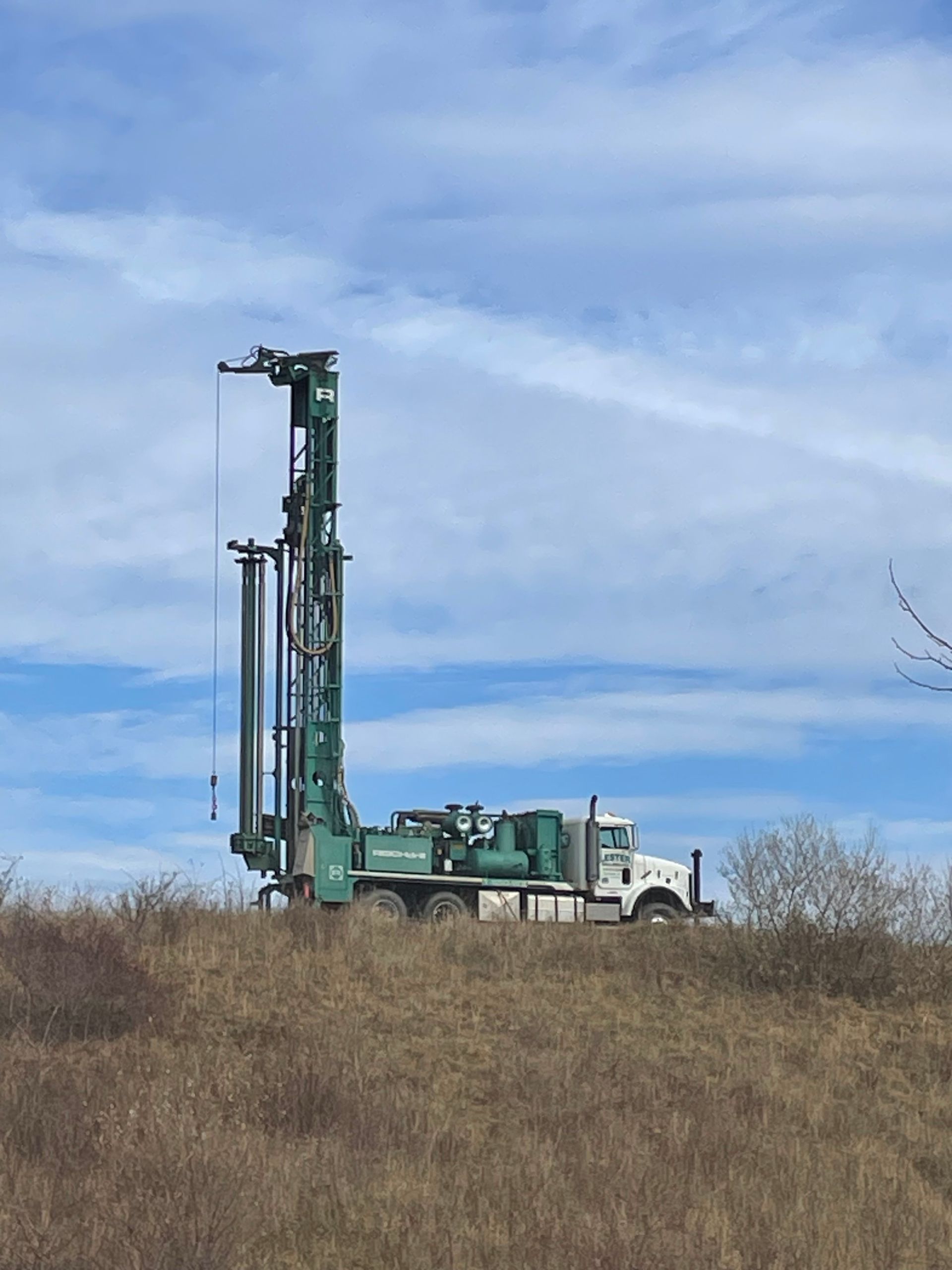 Green Truck Parked on top of a Grassy Hill | Buchanan, VA | Lester Well Drilling Inc