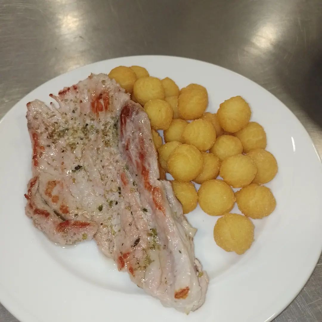 Plato con filete de cerdo a la plancha y croquetas de patata.