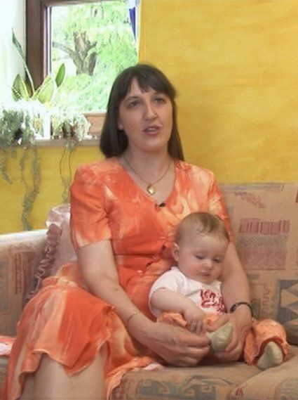 Eine Protagonistin blickt zur Filmemacherin Lydia Oehling, während ihre einjährige Tochter vor ihr sitzt.