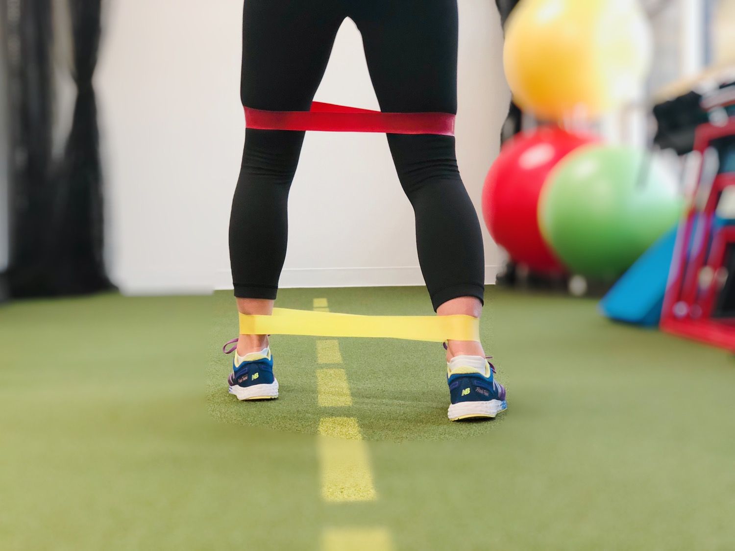 a person is doing exercises with a resistance band in a gym .