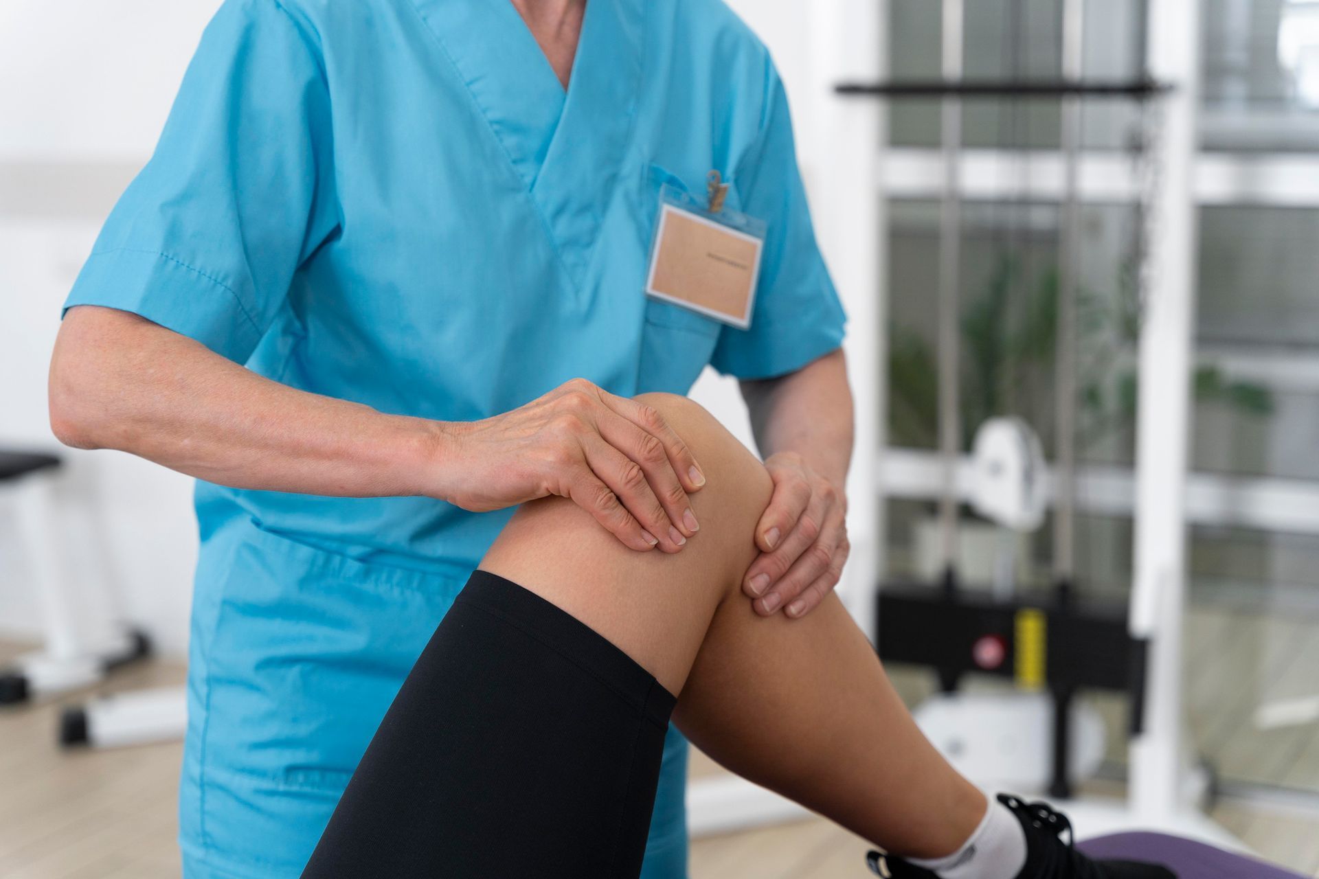 a nurse is examining a patient 's knee in a hospital .