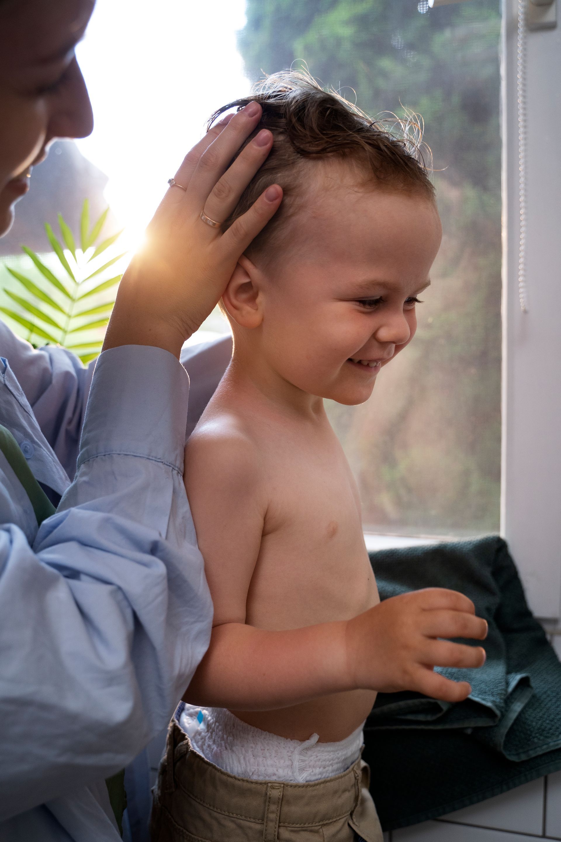 a doctor is examining a young boy 's head for lice .