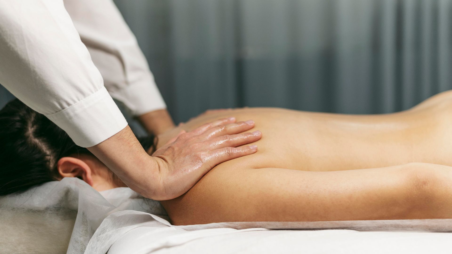 A woman is getting a massage on her back at a spa.