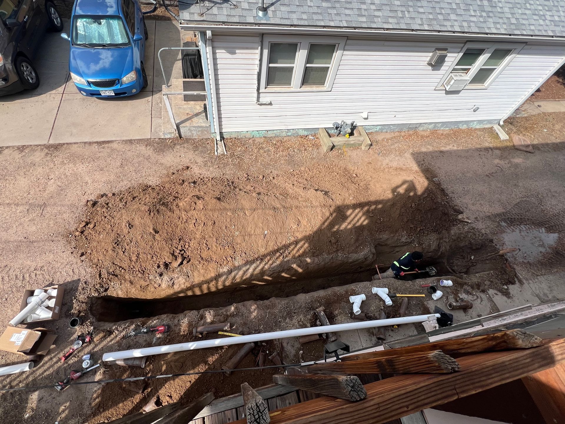 a man is fixing a sink pipe with water coming out of it