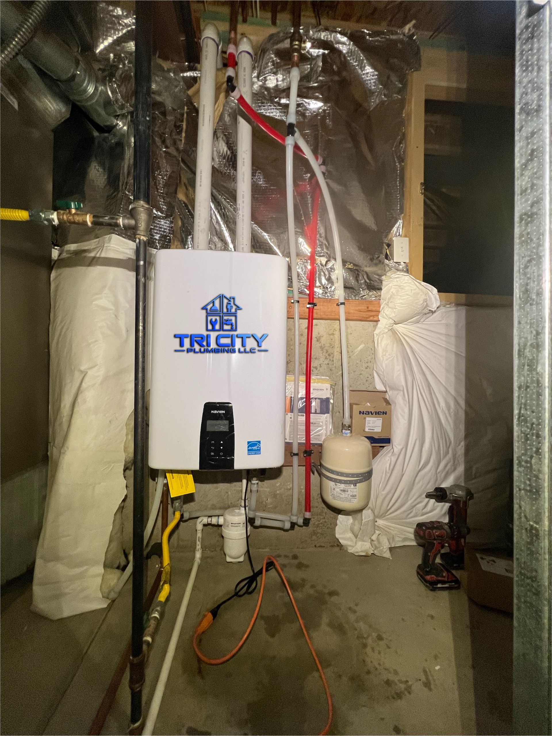 A man is fixing a boiler with a wrench.