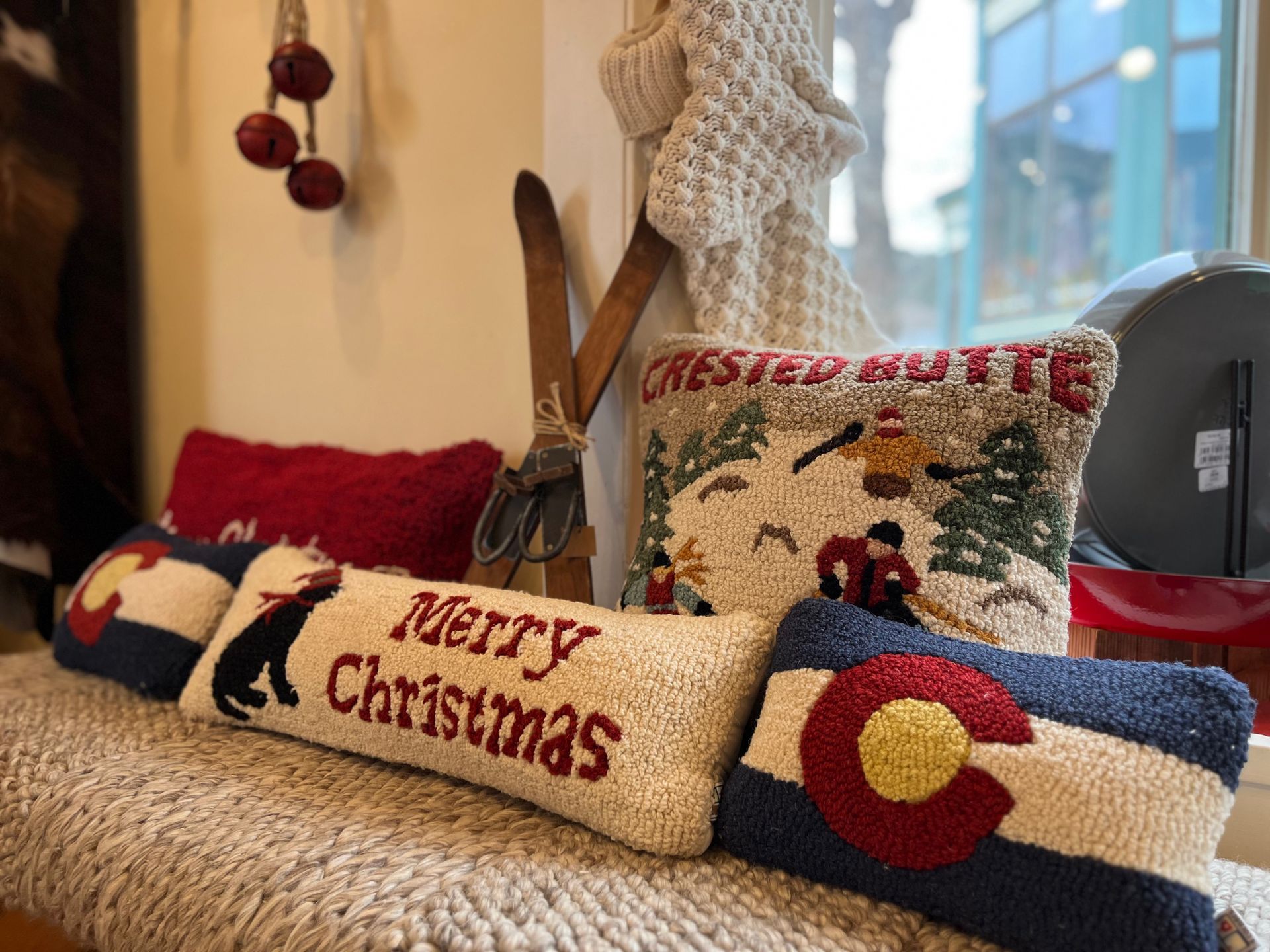 A bunch of christmas pillows are sitting on a bench.
