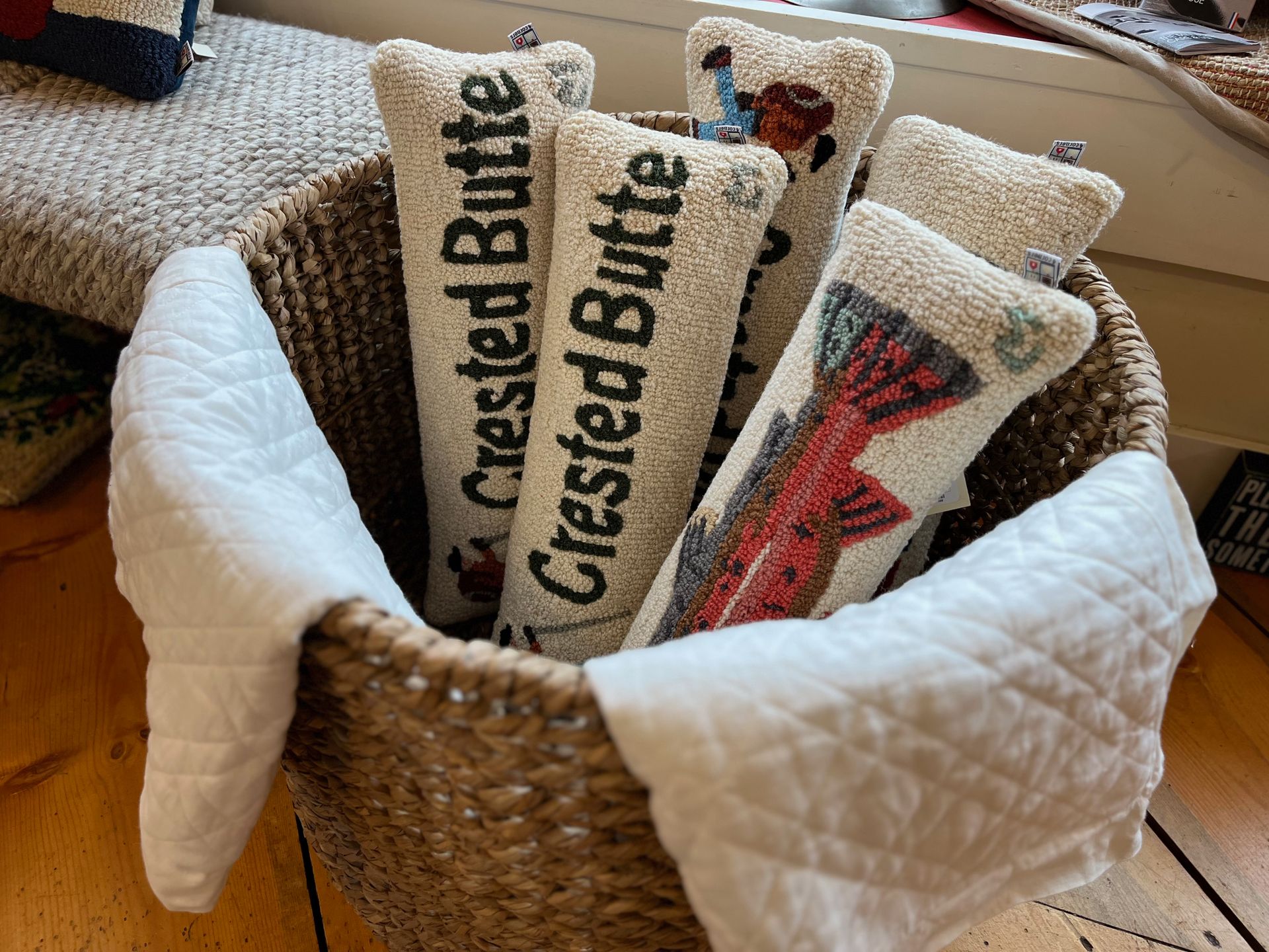 A basket filled with a bunch of pillows that say crested butte