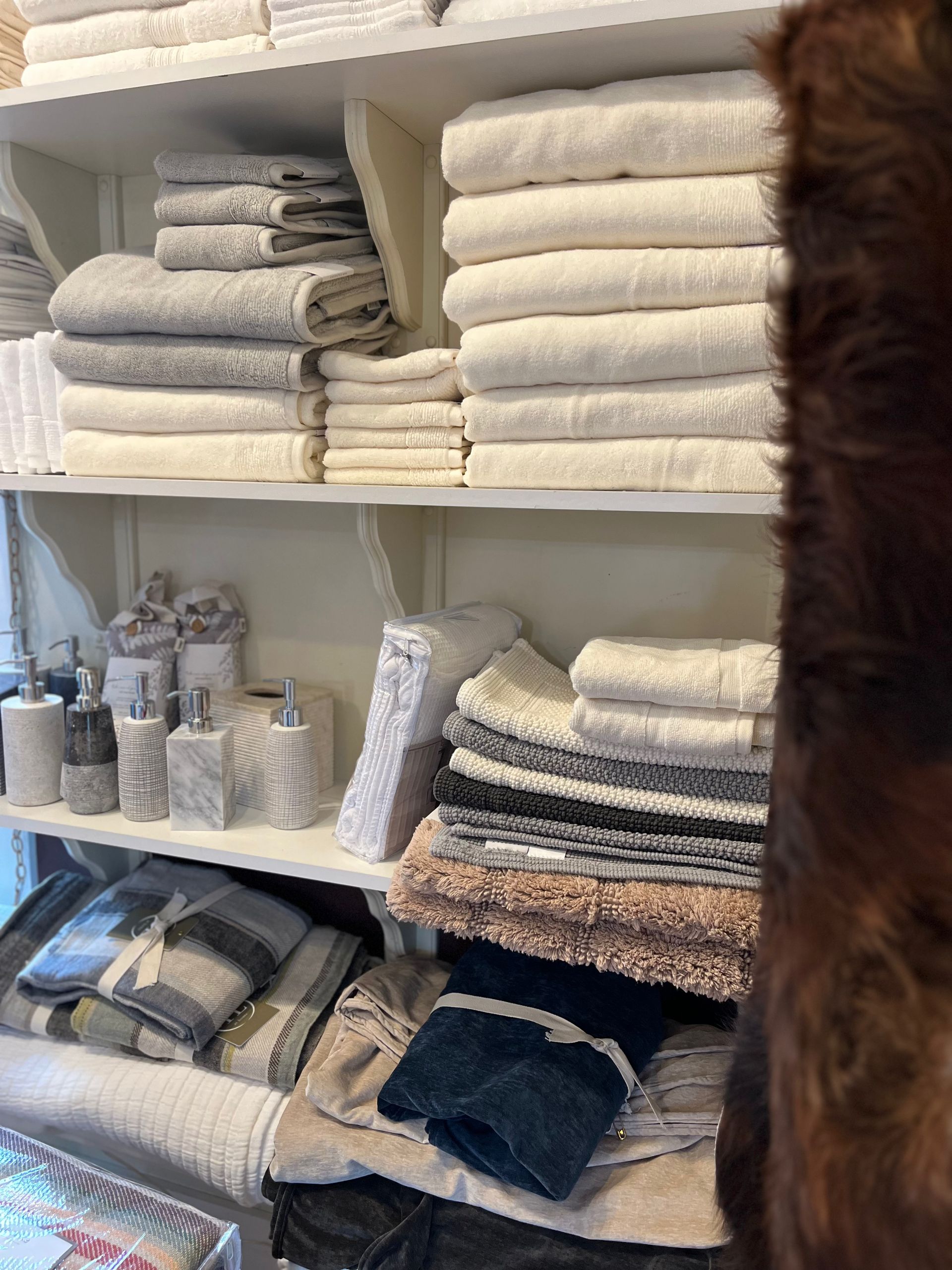 A shelf filled with stacks of towels and soap dispensers.