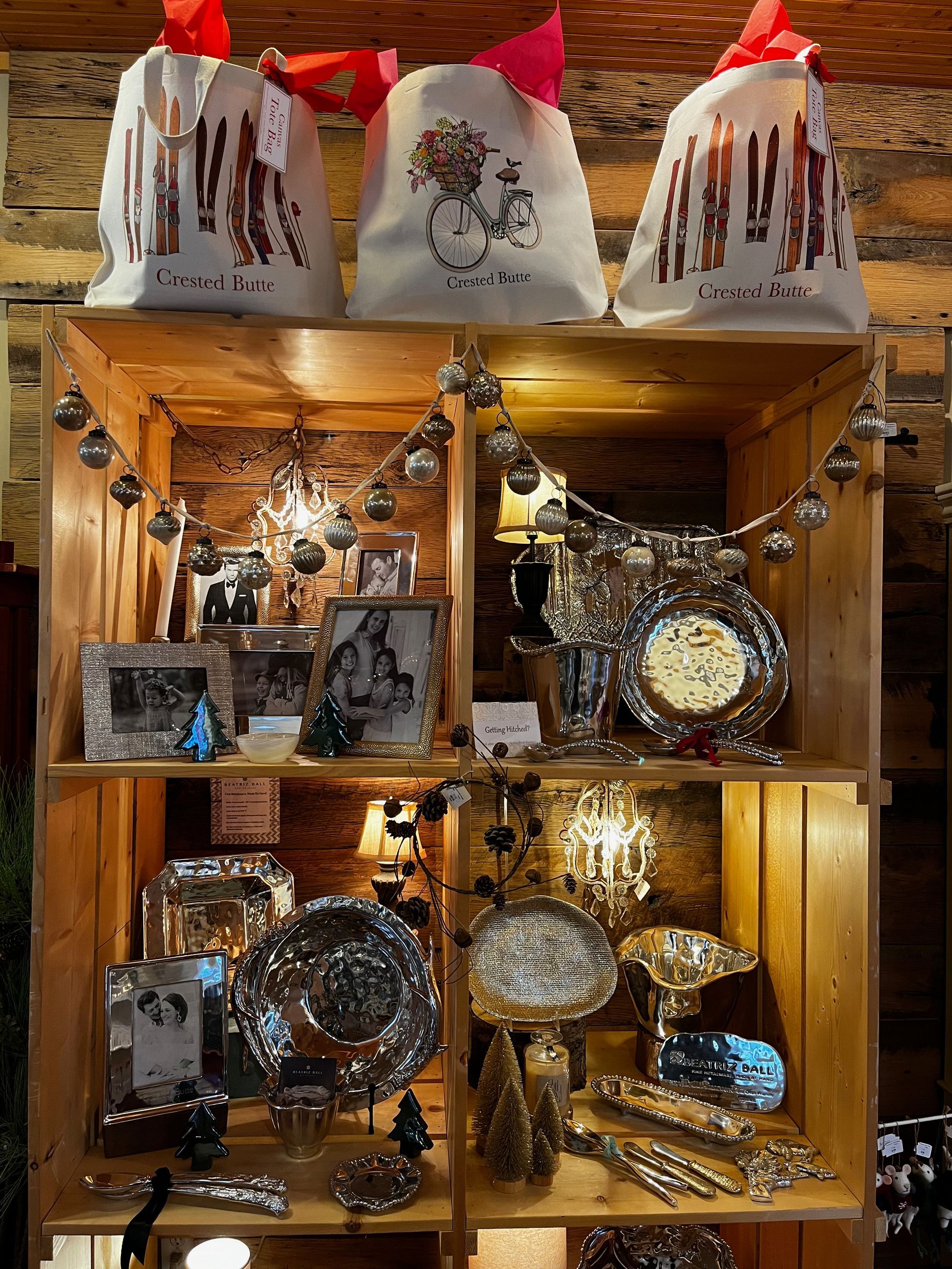 A wooden shelf filled with lots of christmas decorations and gifts.