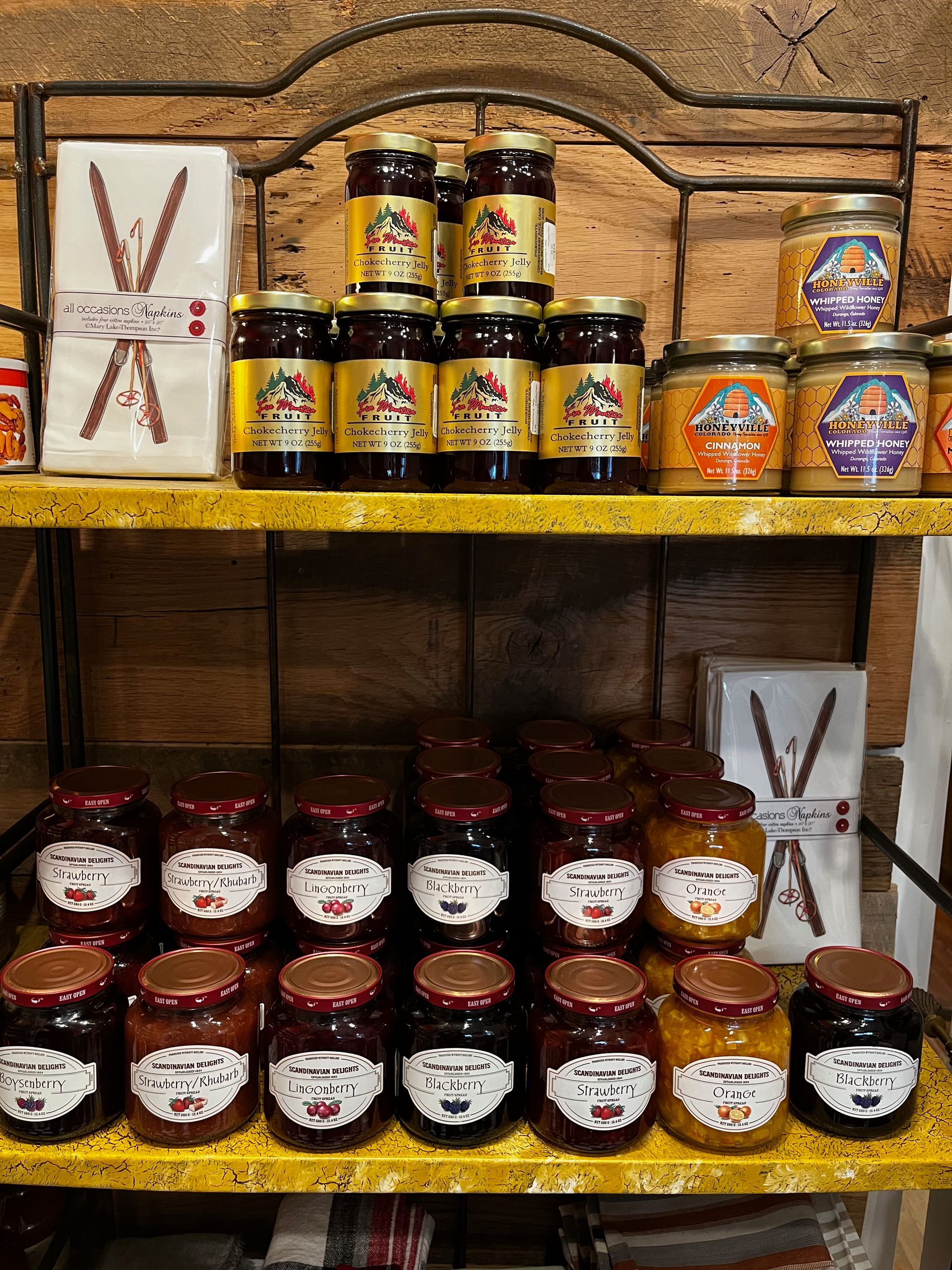 A shelf filled with jars of jam and honey