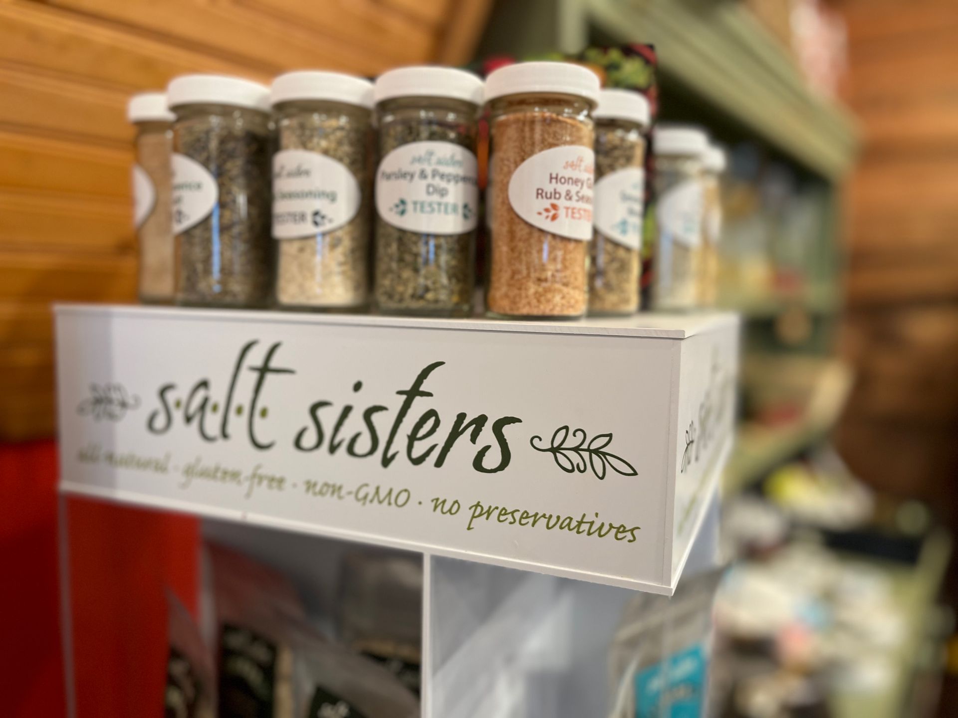 A display of salt sisters spices on a shelf in a store.