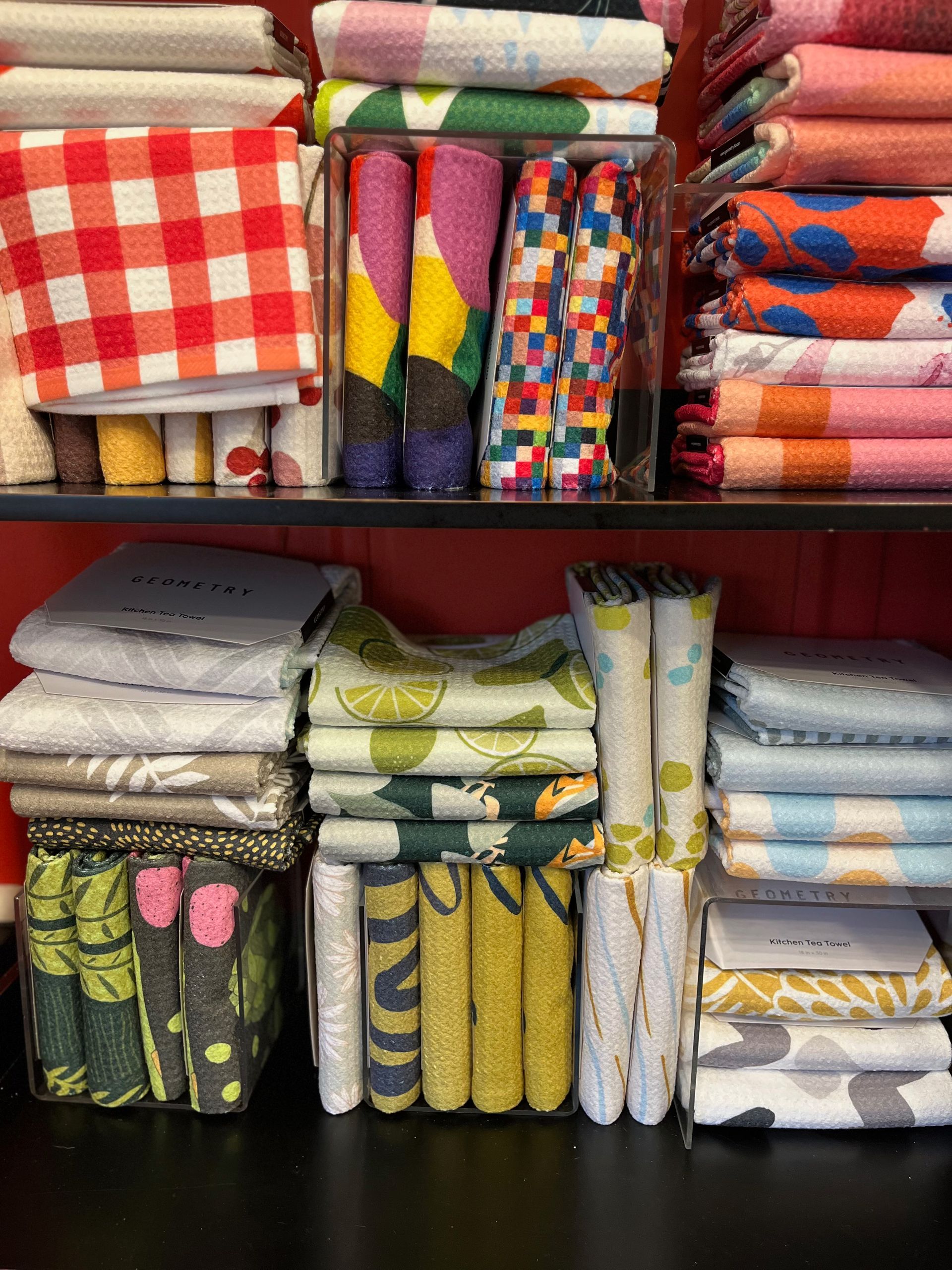 A shelf filled with a variety of colorful towels.