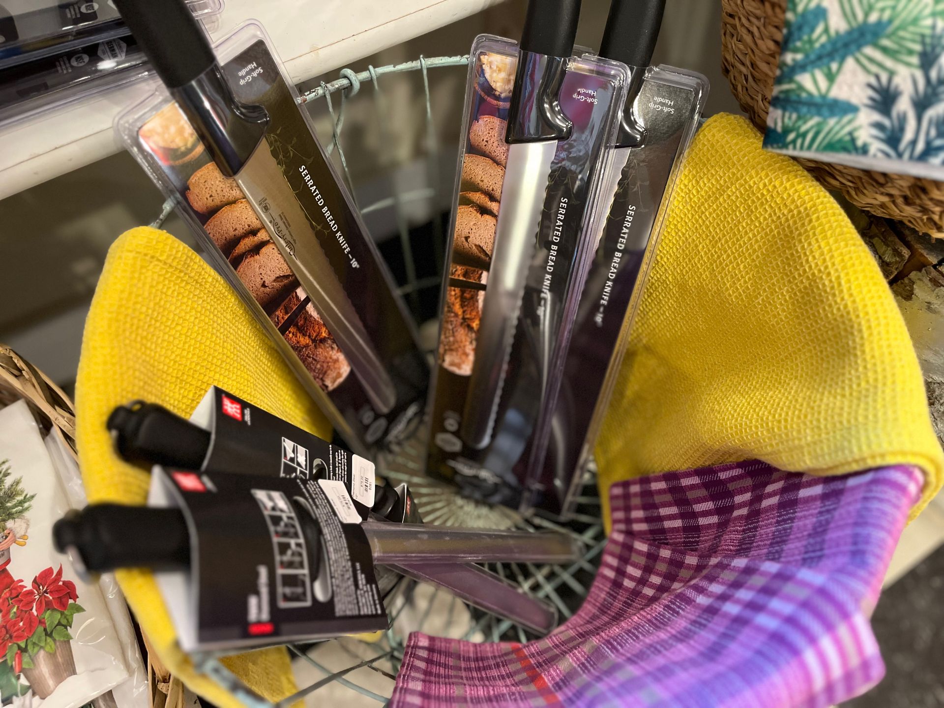 A basket filled with knives and a purple towel.