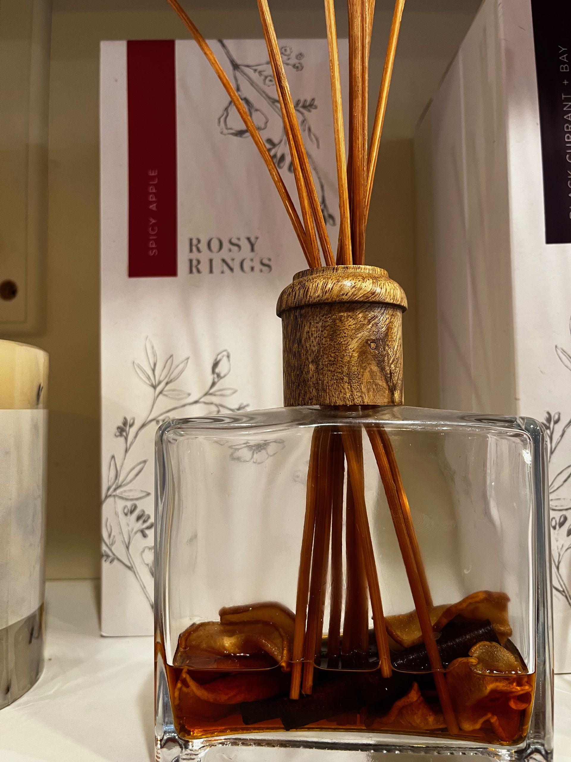 A bottle of rosy rings reed diffuser with sticks in it