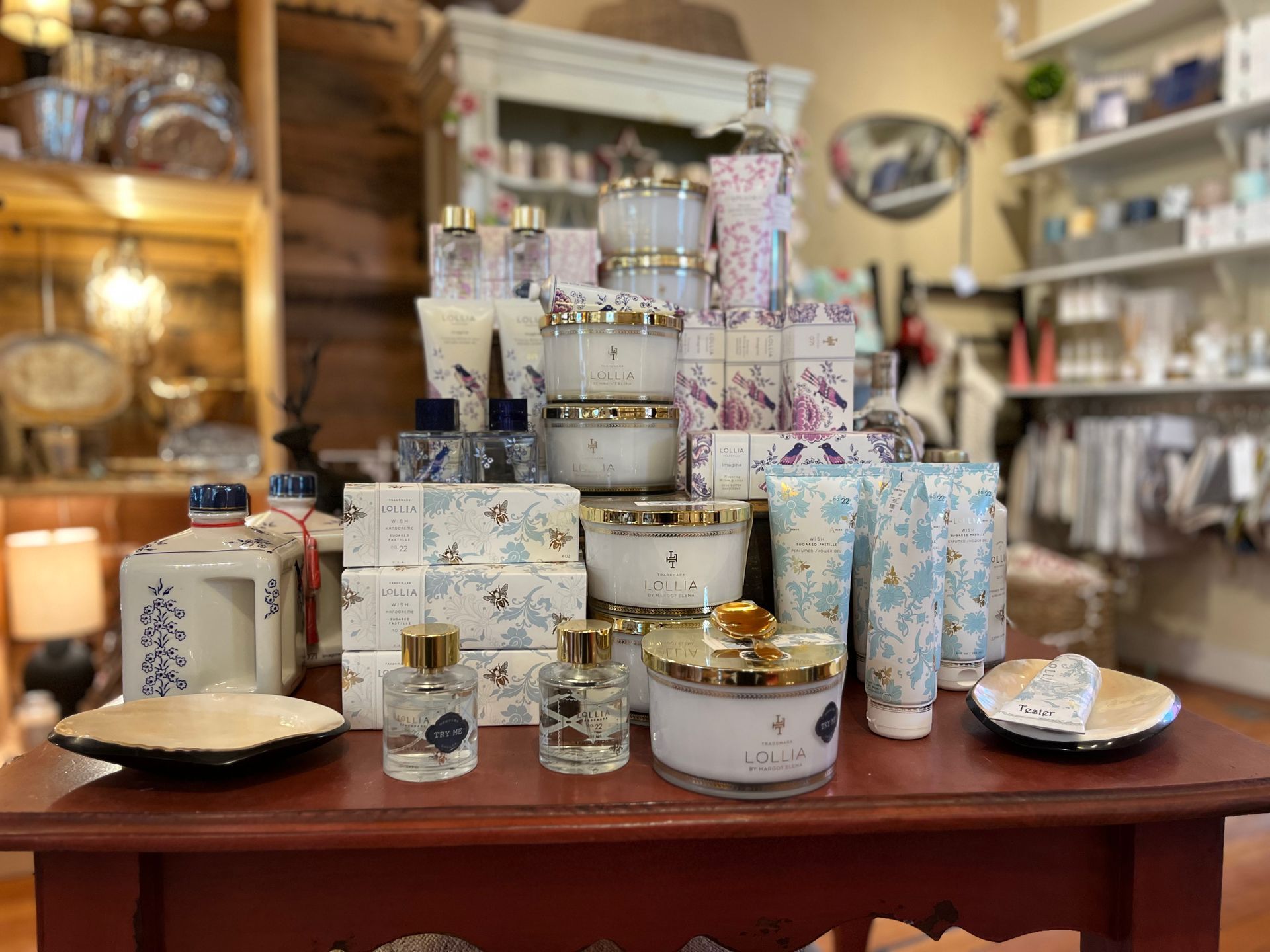 A table with a lot of candles on it in a store.