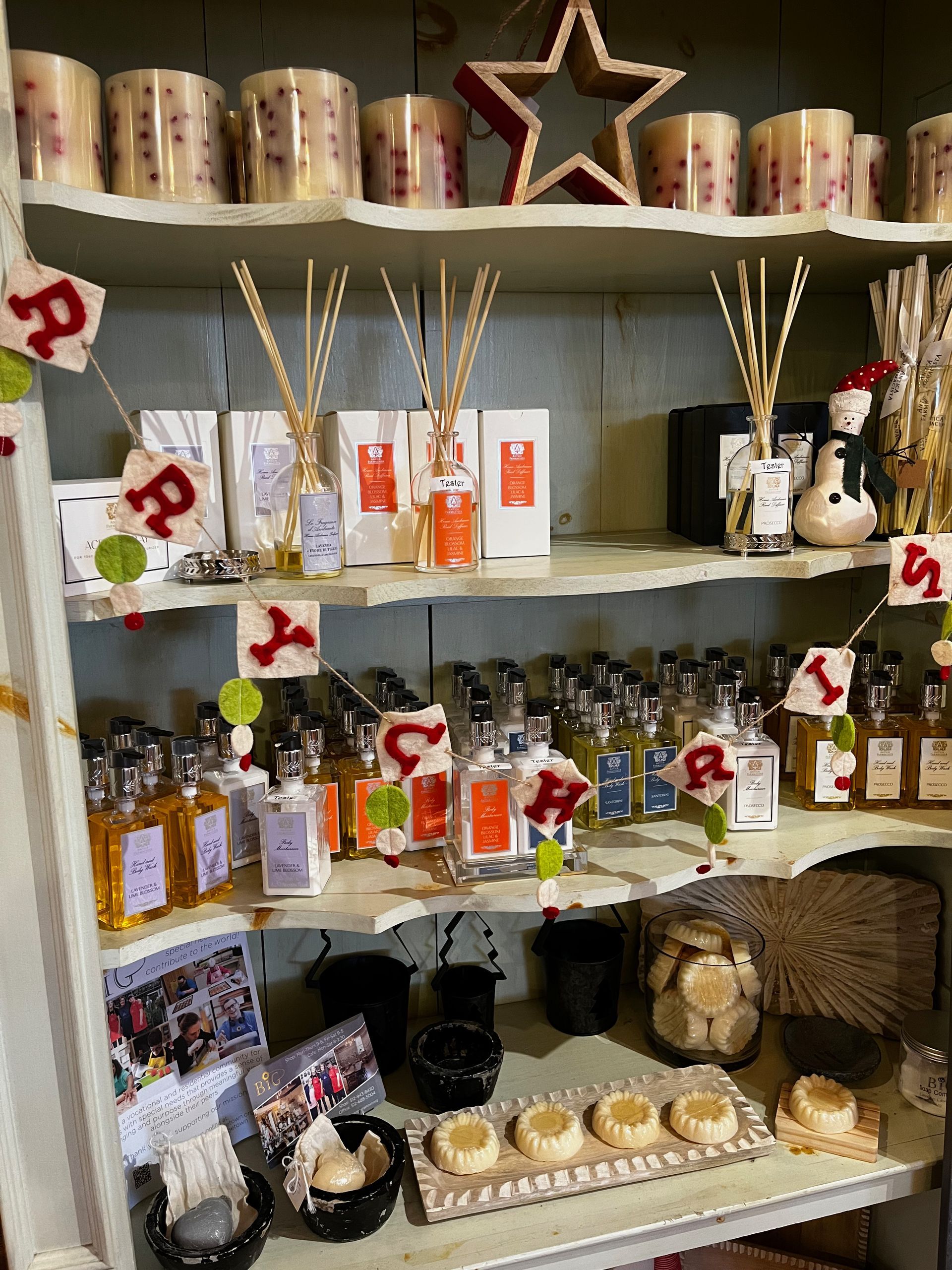 A shelf filled with lots of bottles of perfume and candles.