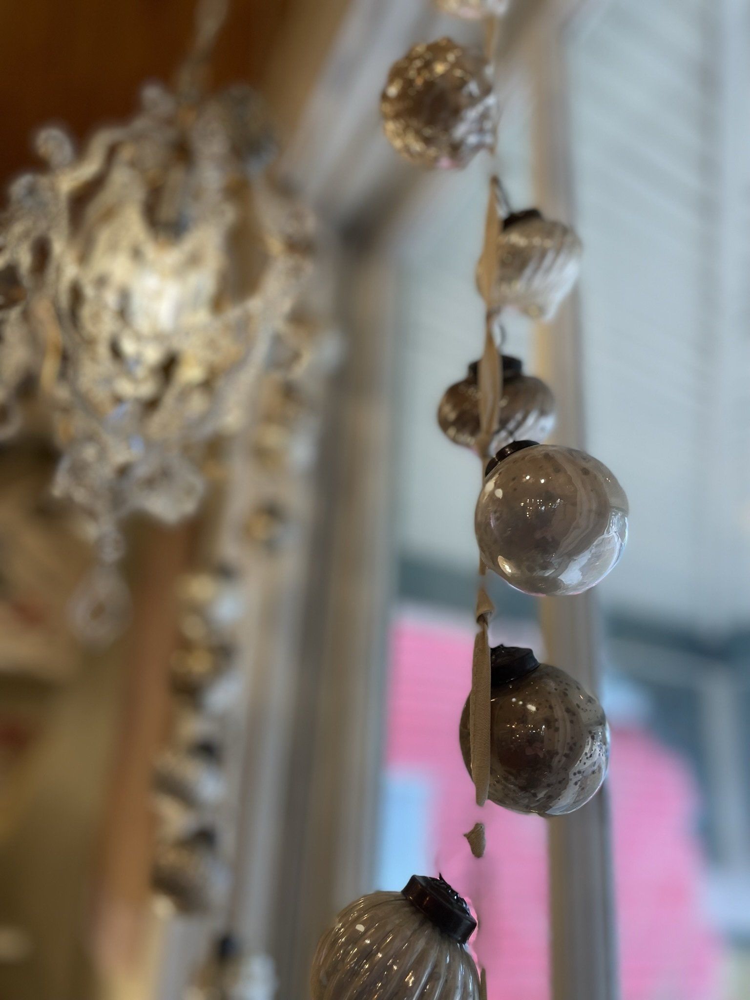 A string of christmas ornaments hanging from the ceiling in a room.