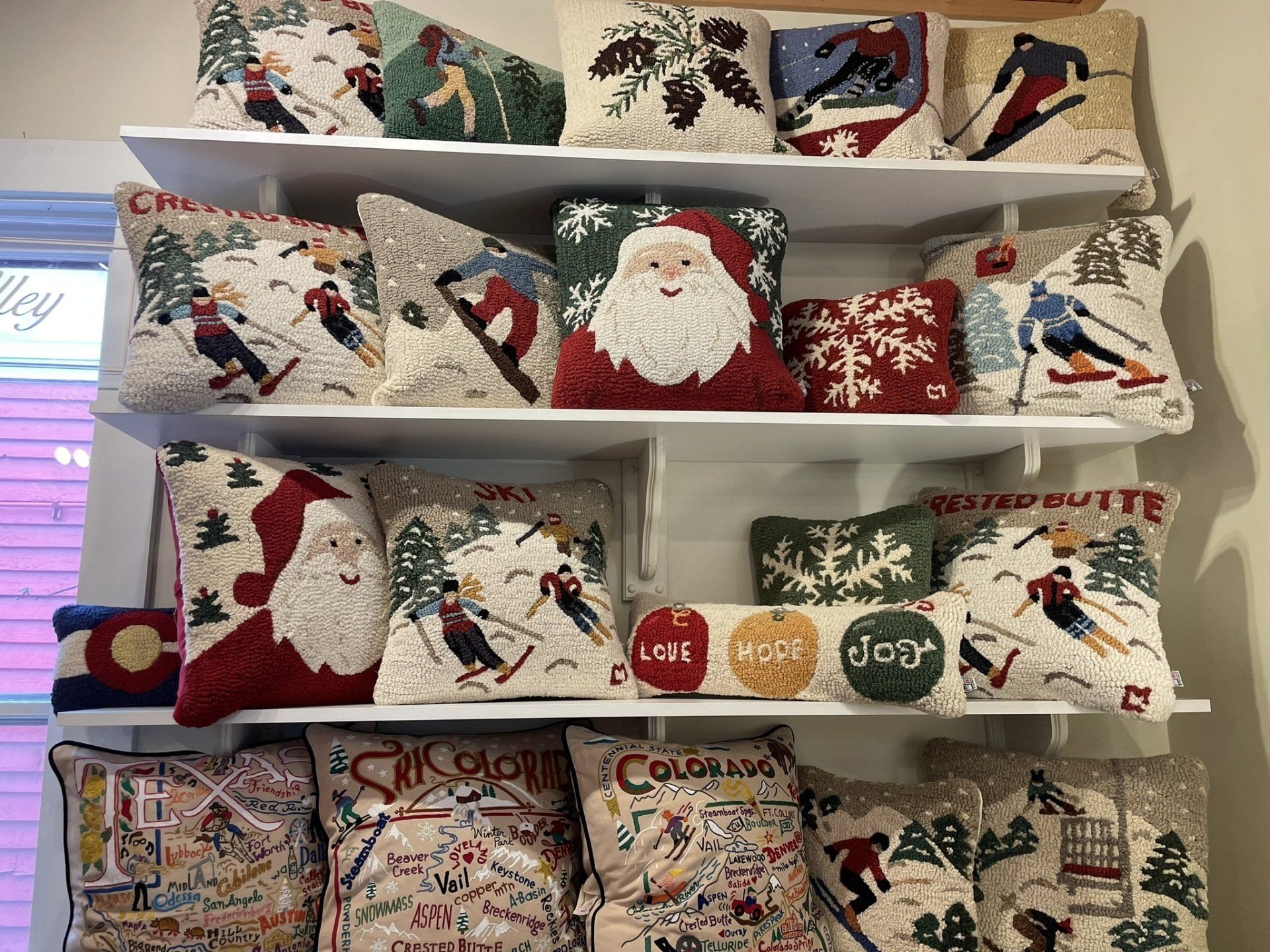 There are many different types of pillows on the shelves.