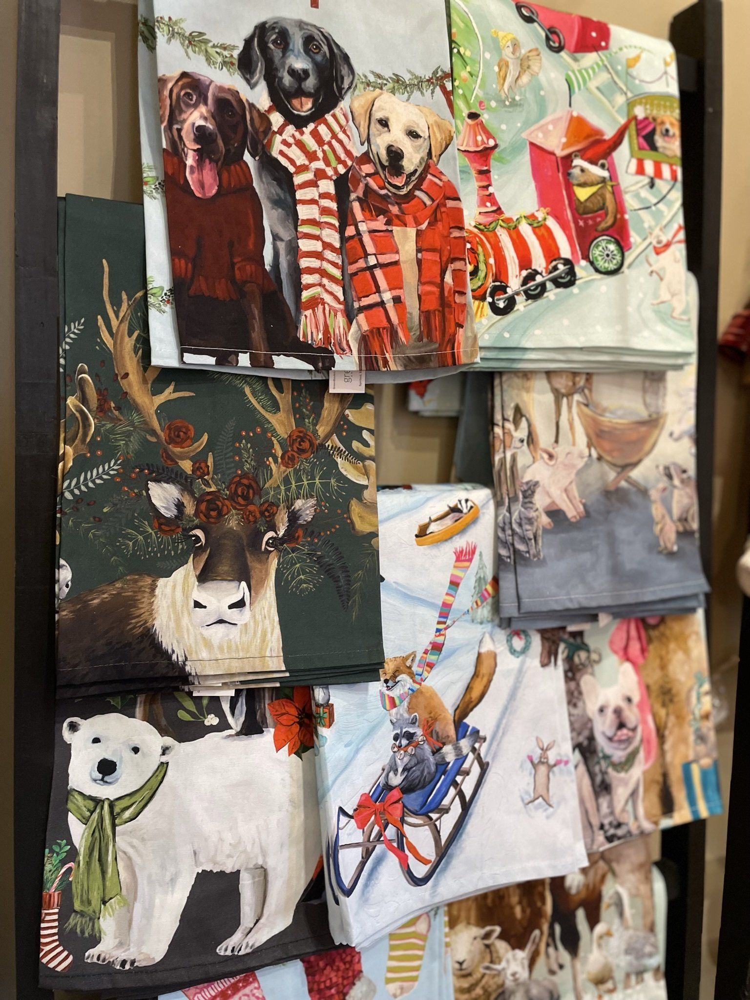 A bunch of towels with dogs on them are hanging on a rack.