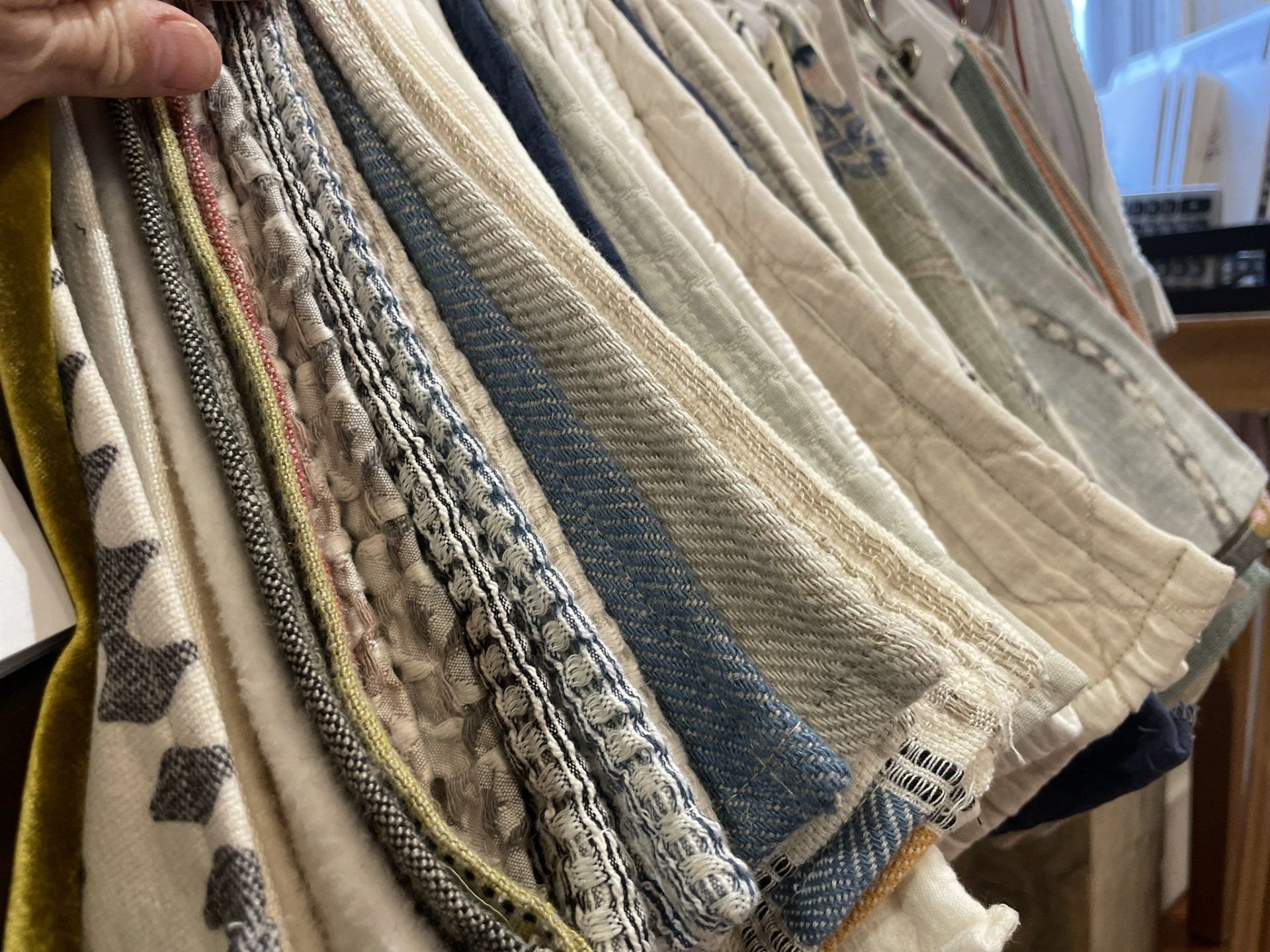 A person is holding a pile of blankets in their hand.