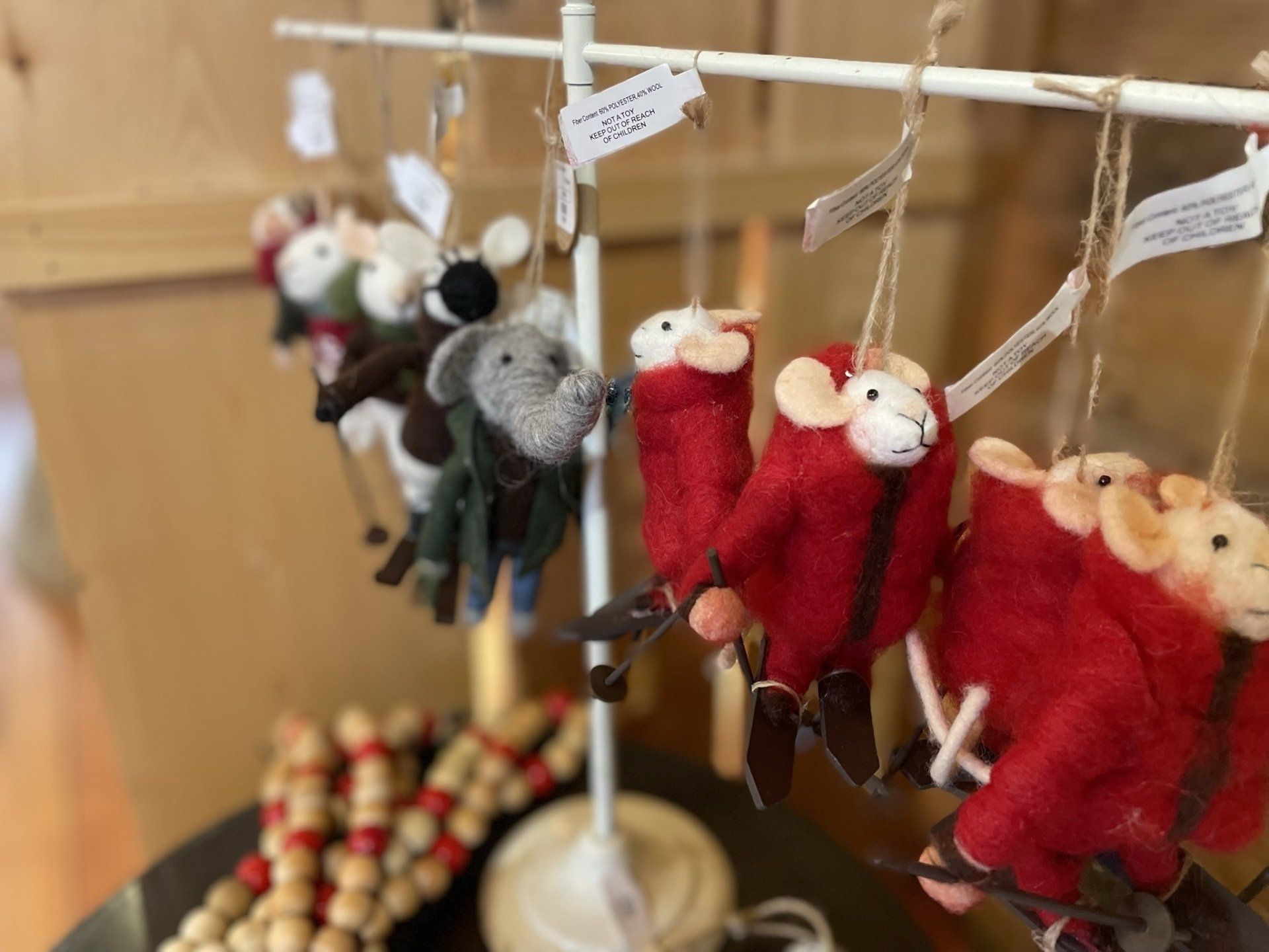 A bunch of stuffed animals are hanging from a pole on a table.