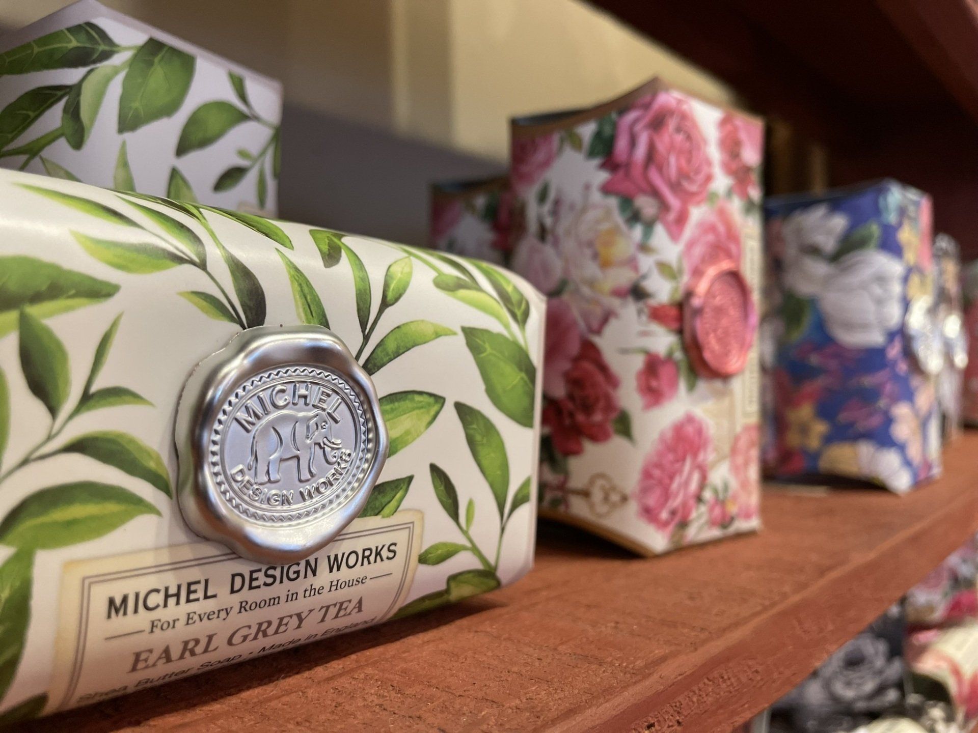 A shelf filled with various soaps including michel design works earl grey tea