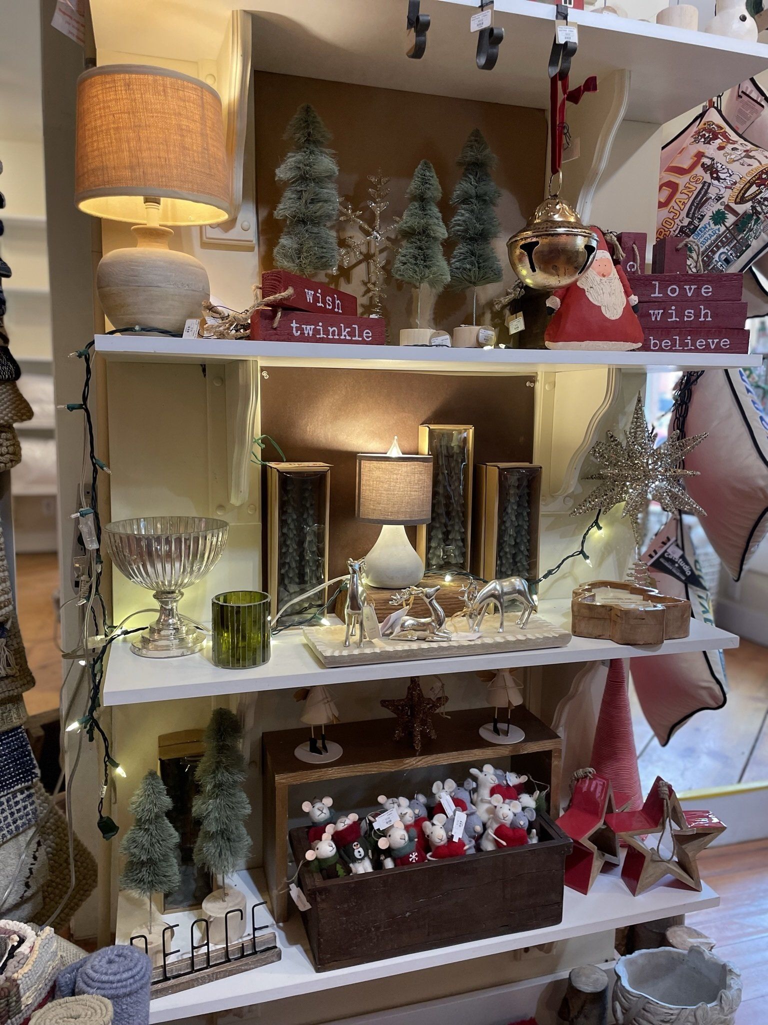 A shelf filled with lots of christmas decorations and lamps.