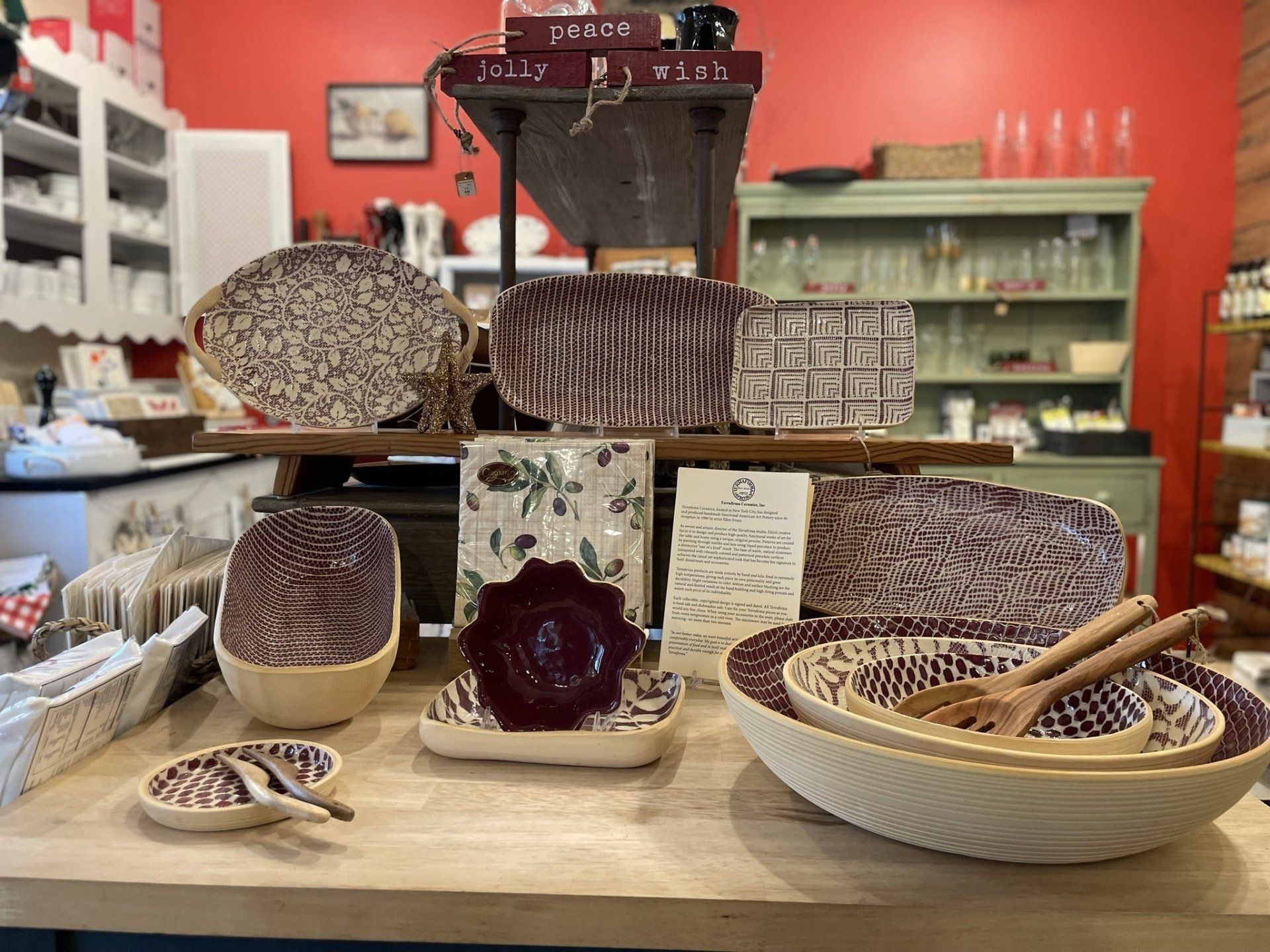 A table topped with bowls , plates , and spoons in a kitchen.