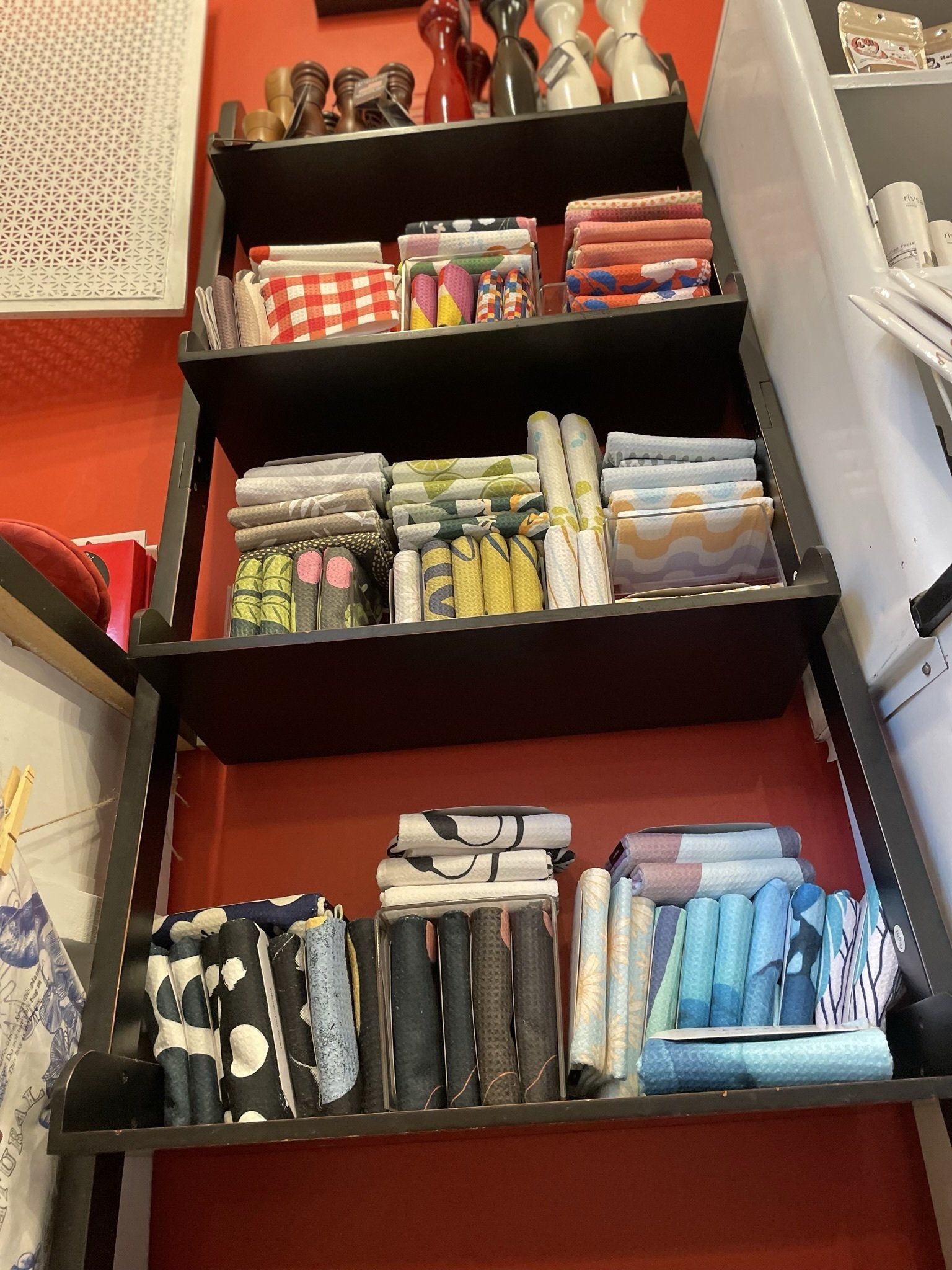 A drawer filled with lots of different types of fabrics.
