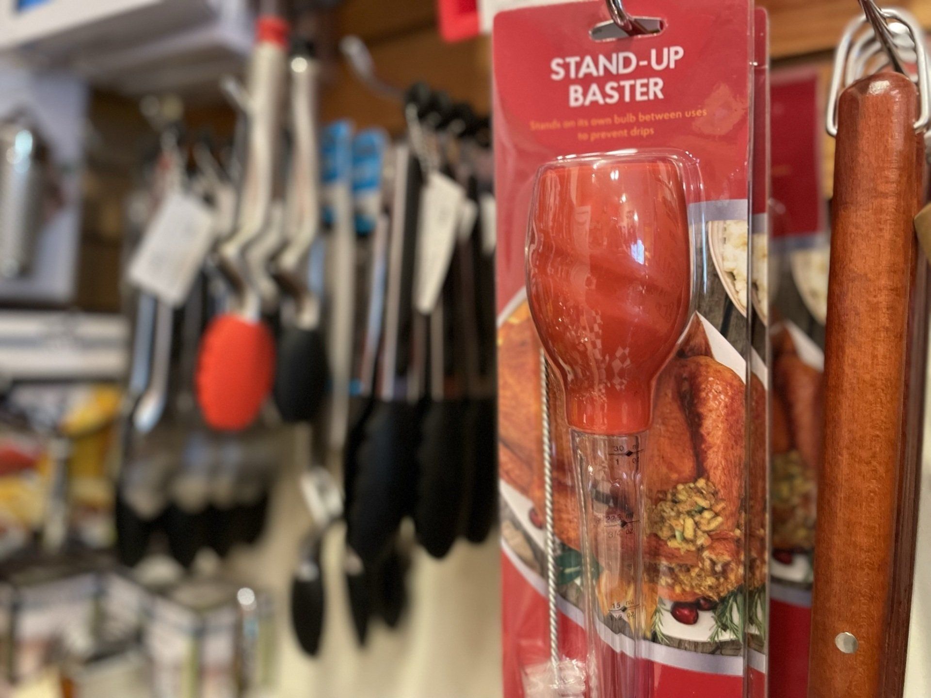 A stand up baster is hanging on a shelf in a store