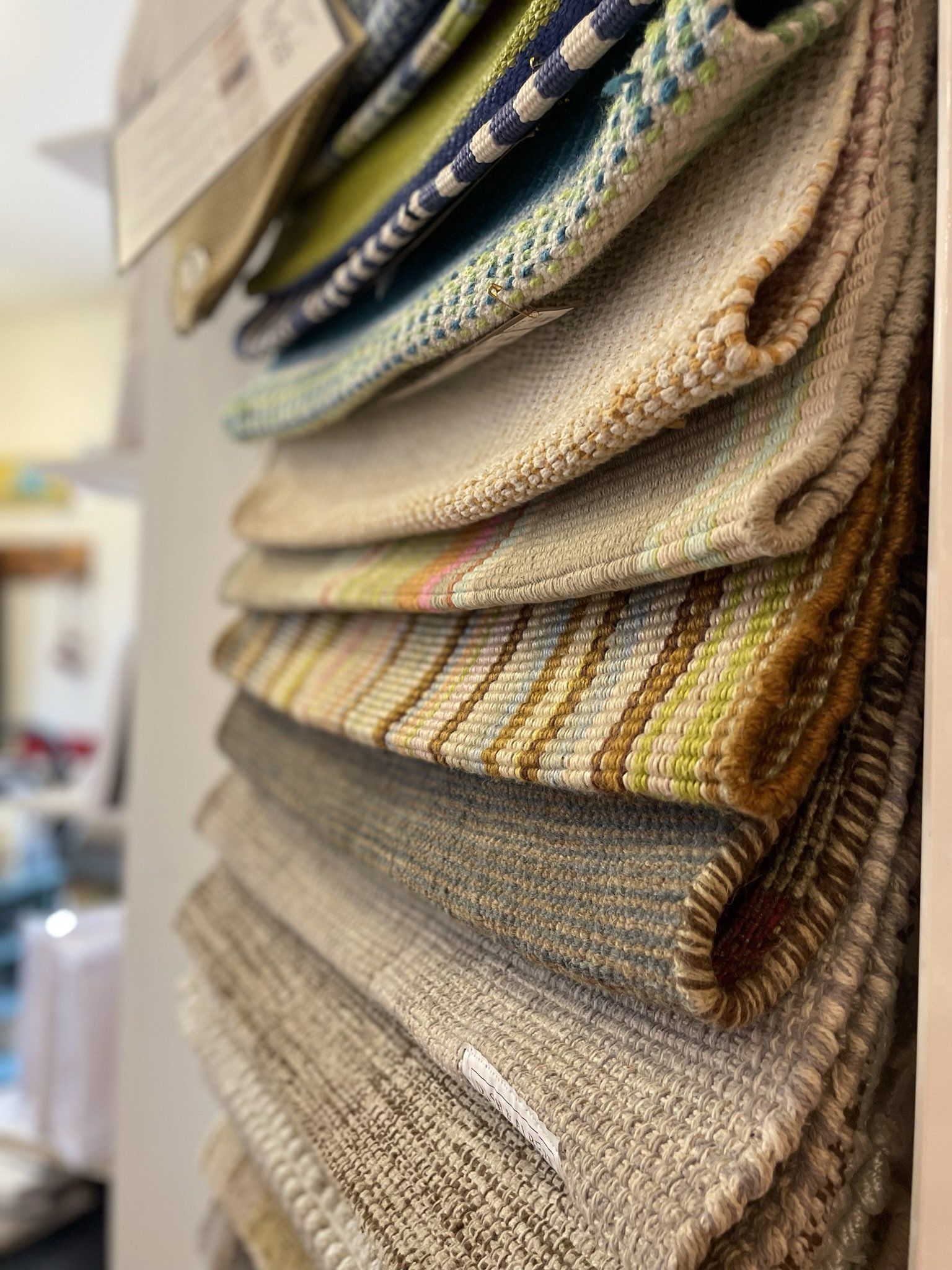 A stack of fabrics hanging on a wall in a store.