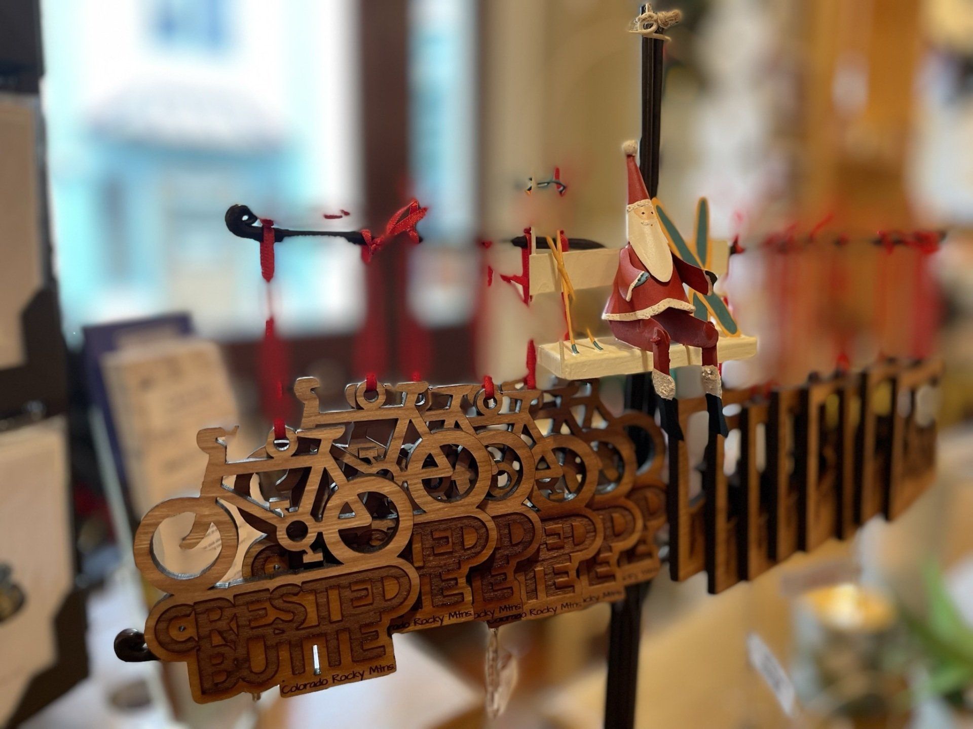 A wooden sign with a santa claus on it is hanging on a pole.