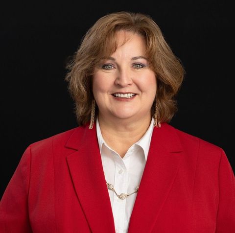 A man wearing glasses and a plaid shirt is smiling for the camera.
