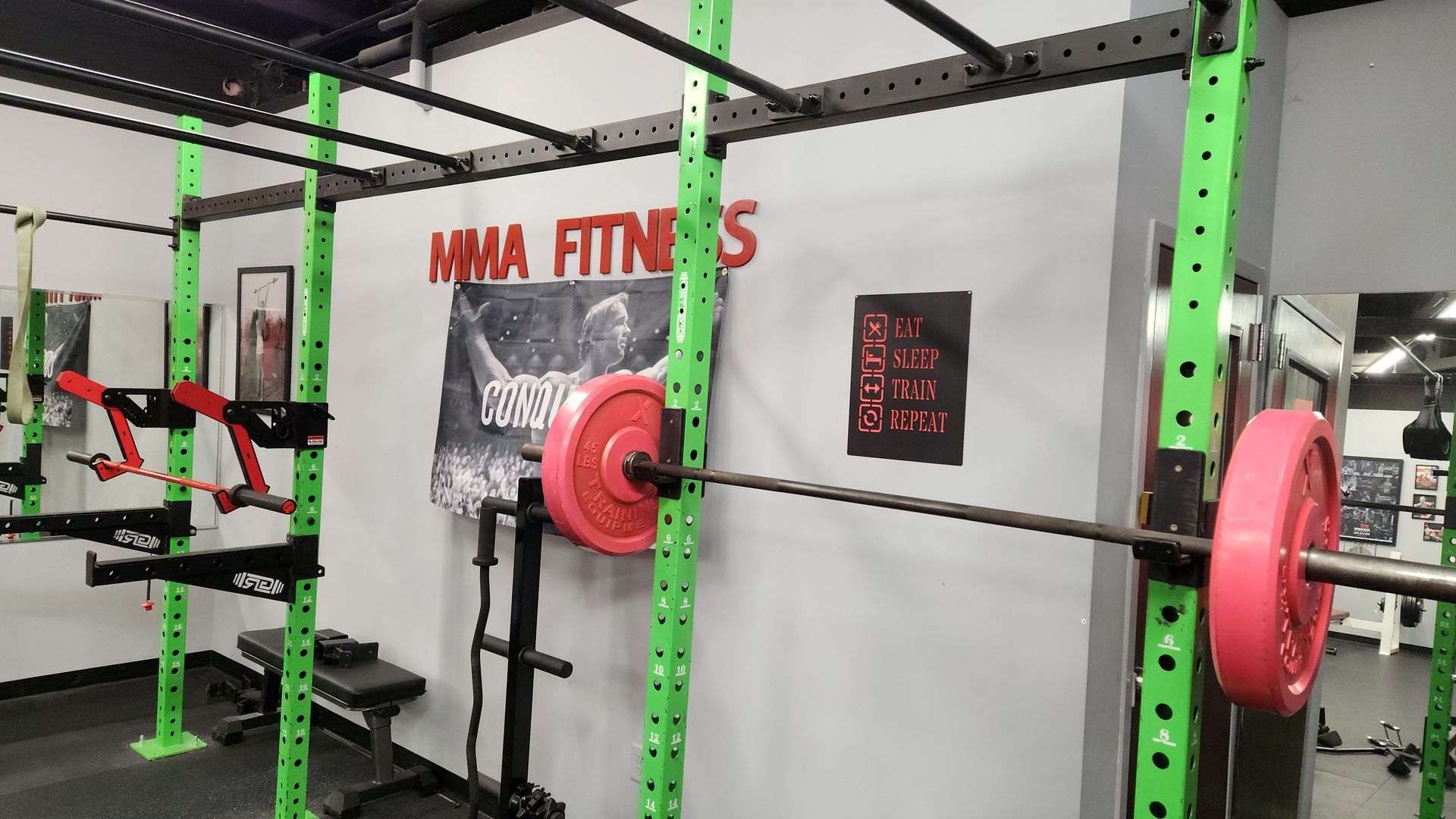 A gym with a barbell in a squat rack.