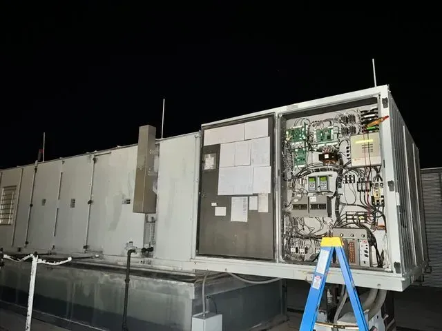 A ladder is sitting on top of a large electrical box.