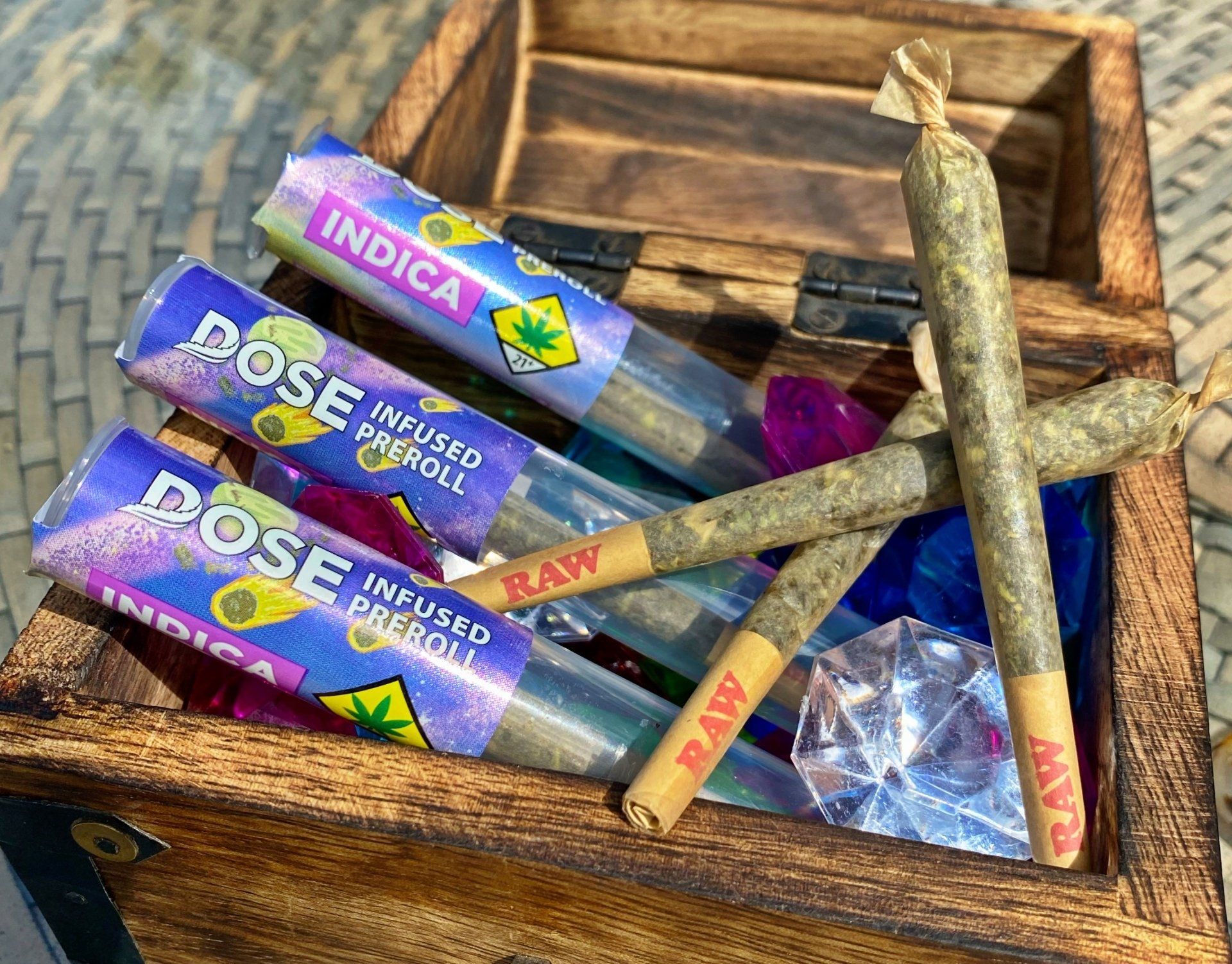 A wooden box filled with pre rolled joints.
