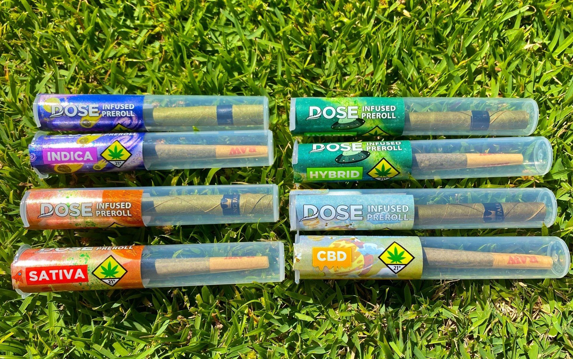 A bunch of pre rolled joints are sitting on top of a lush green field.