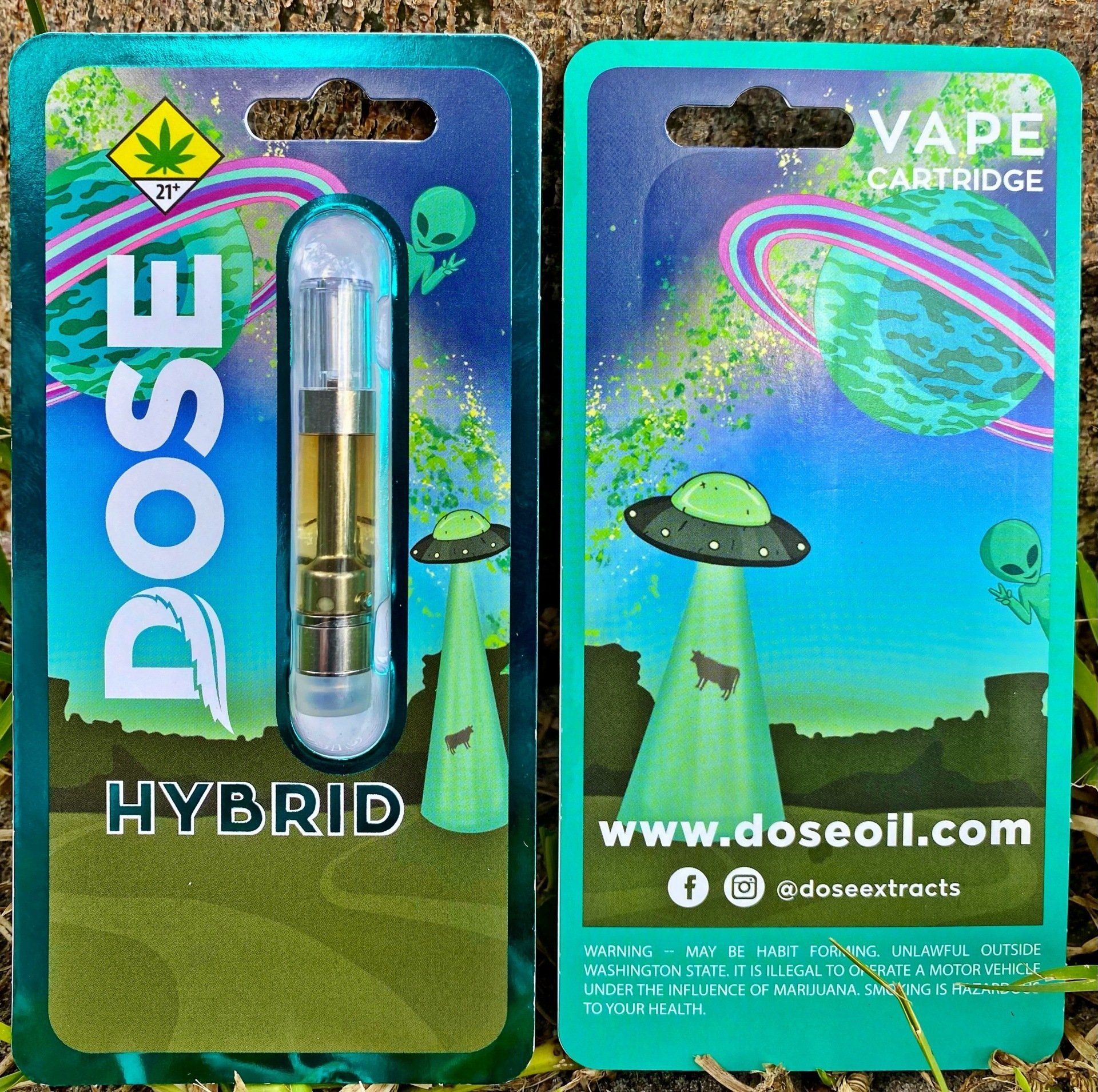 A dose hybrid vape cartridge is sitting on the ground.