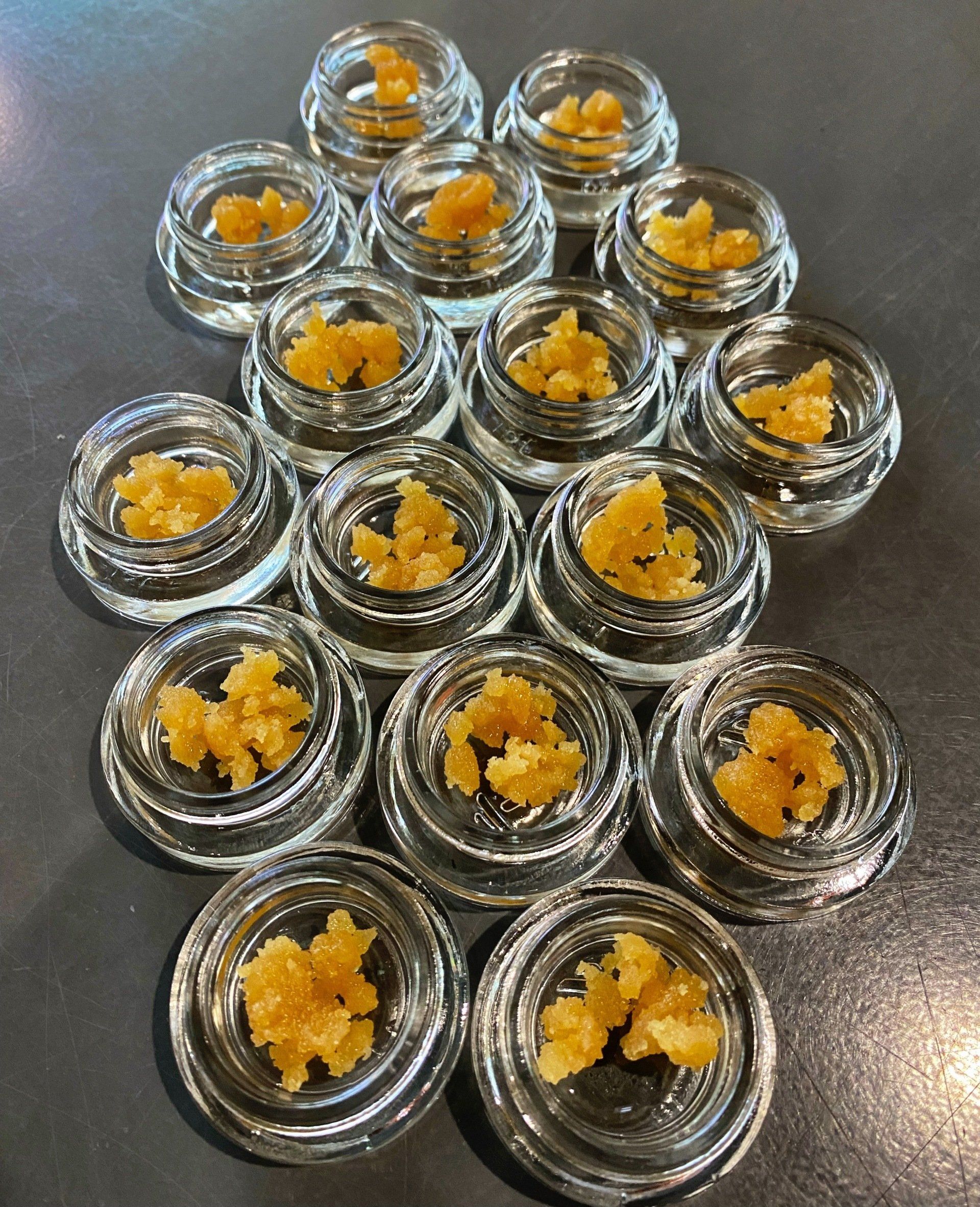 A bunch of jars filled with a yellow substance on a table.