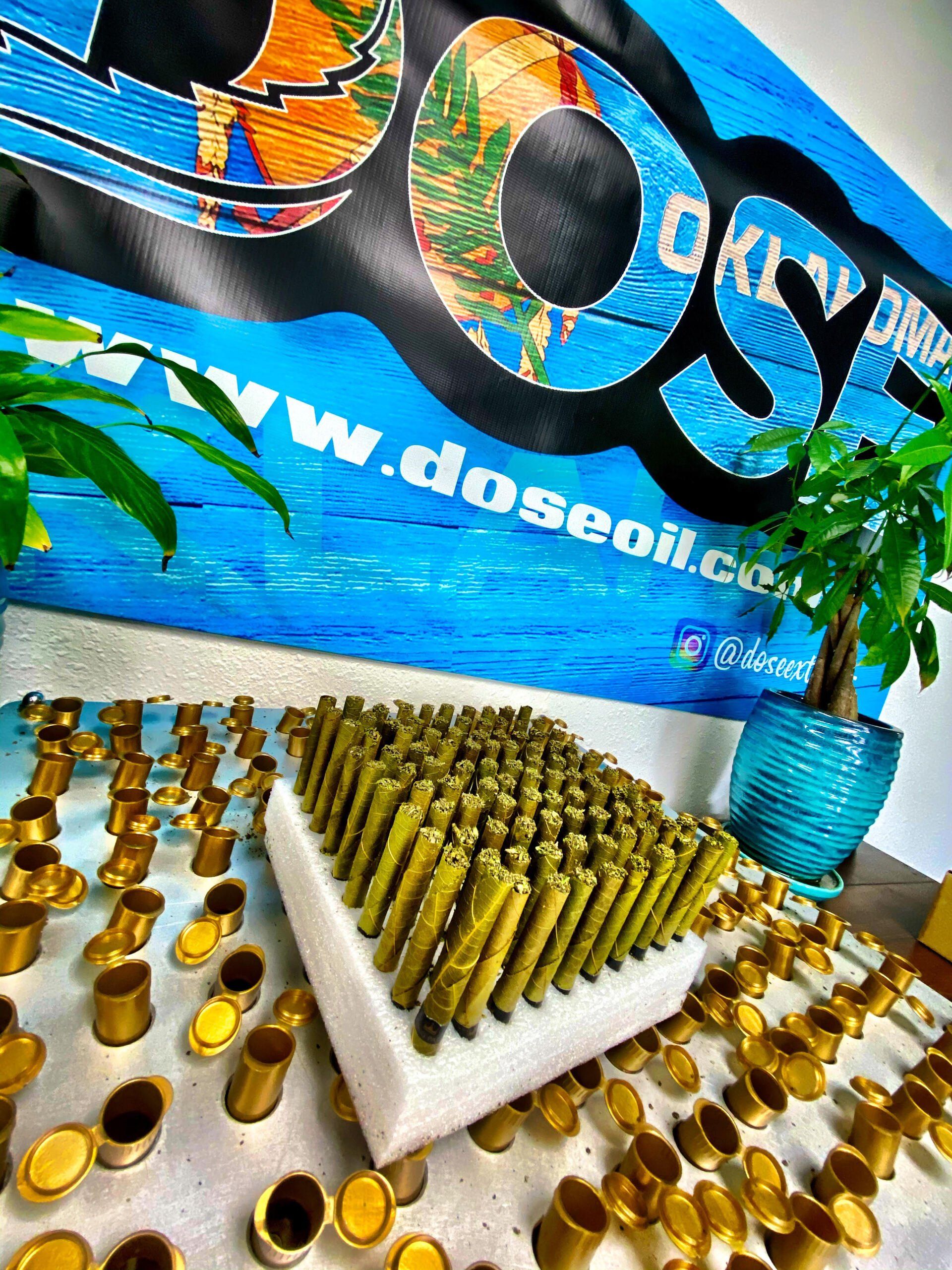 A bunch of bullets are on a table in front of a sign that says dose oil