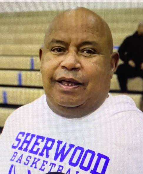A man wearing a shirt that says sherwood basketball