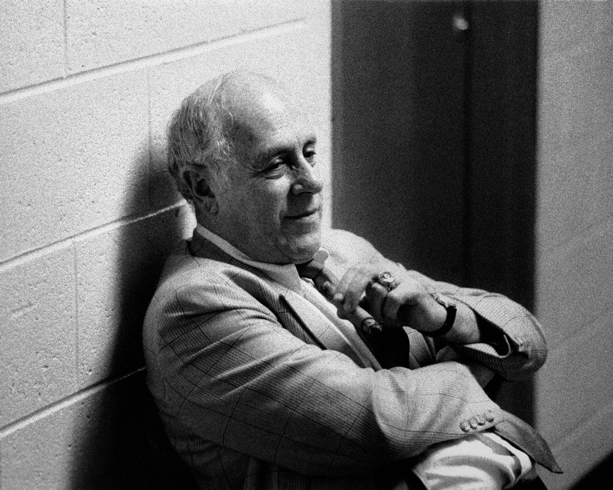 A man leaning against a brick wall with his arms crossed