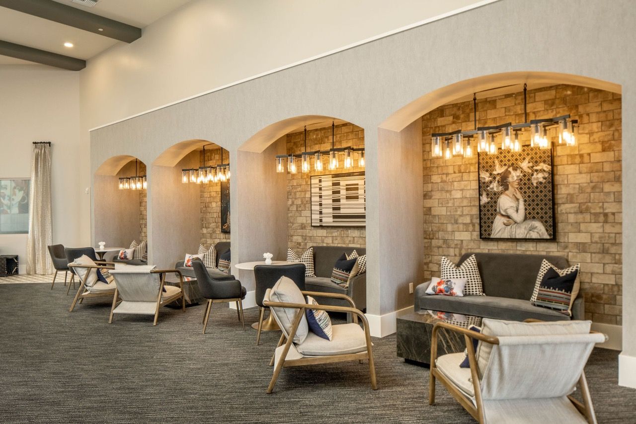 Indoor community lounge with arched alcoves, brick walls, and comfortable seating.