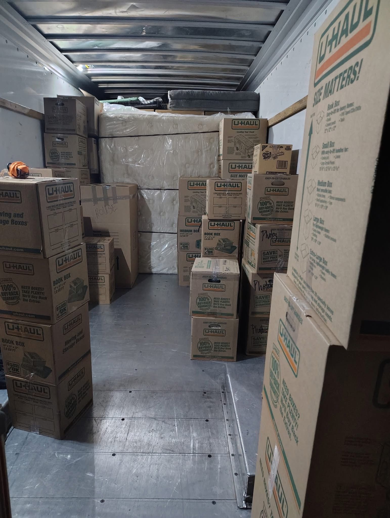 Inside of a U-Haul truck filled with cardboard moving boxes, ready for transport.