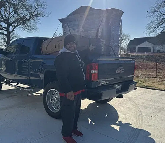 A man is standing in front of a gmc truck