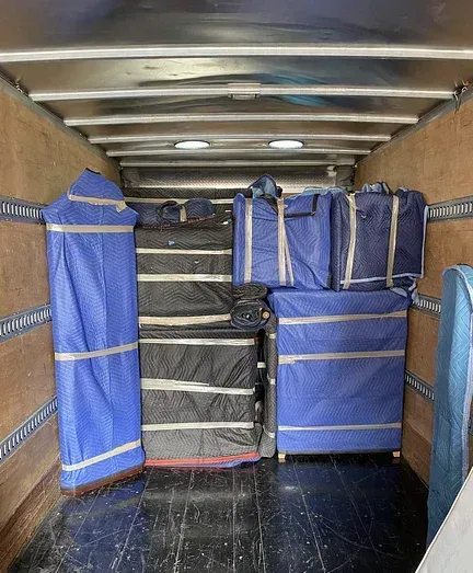 The inside of a moving truck filled with boxes and bags.