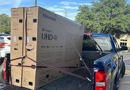 A hisense uhd 4k television is sitting in the back of a truck.