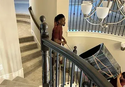 A man is carrying a box up a set of stairs.